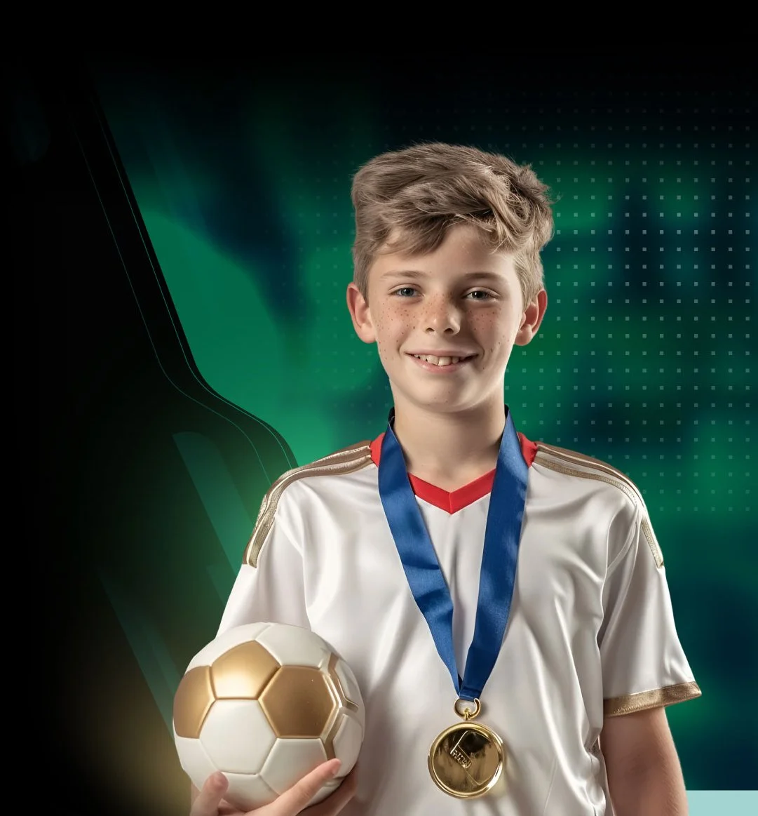 Young boy in a white soccer jersey with gold accents, wearing a blue medal around his neck, holding a soccer ball with gold and white panels, smiling after winning a sports award.