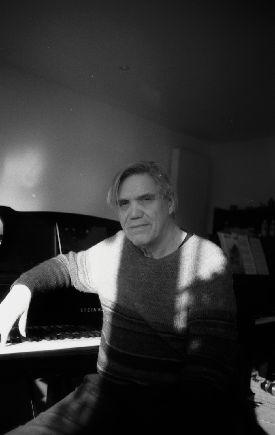 Komponist, Gitarrist & musikalischer Leiter Erich A. Radke vor dem Klavier.