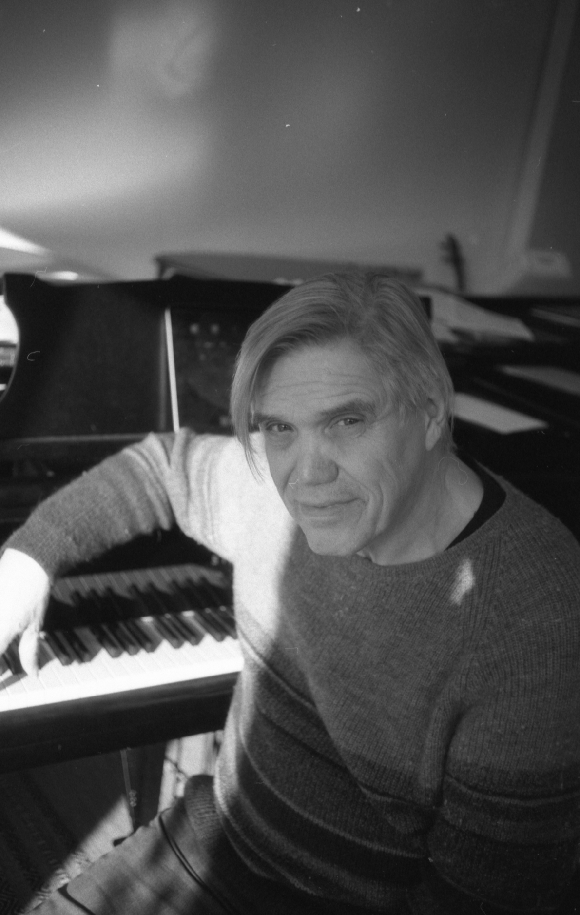 Komponist, Gitarrist & musikalischer Leiter Erich A. Radke vor dem Klavier.