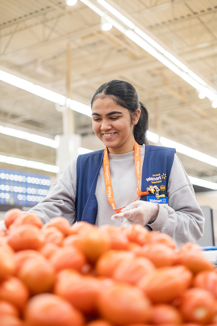 A Walmart employee shopping for onions in the produce section at Walmart.