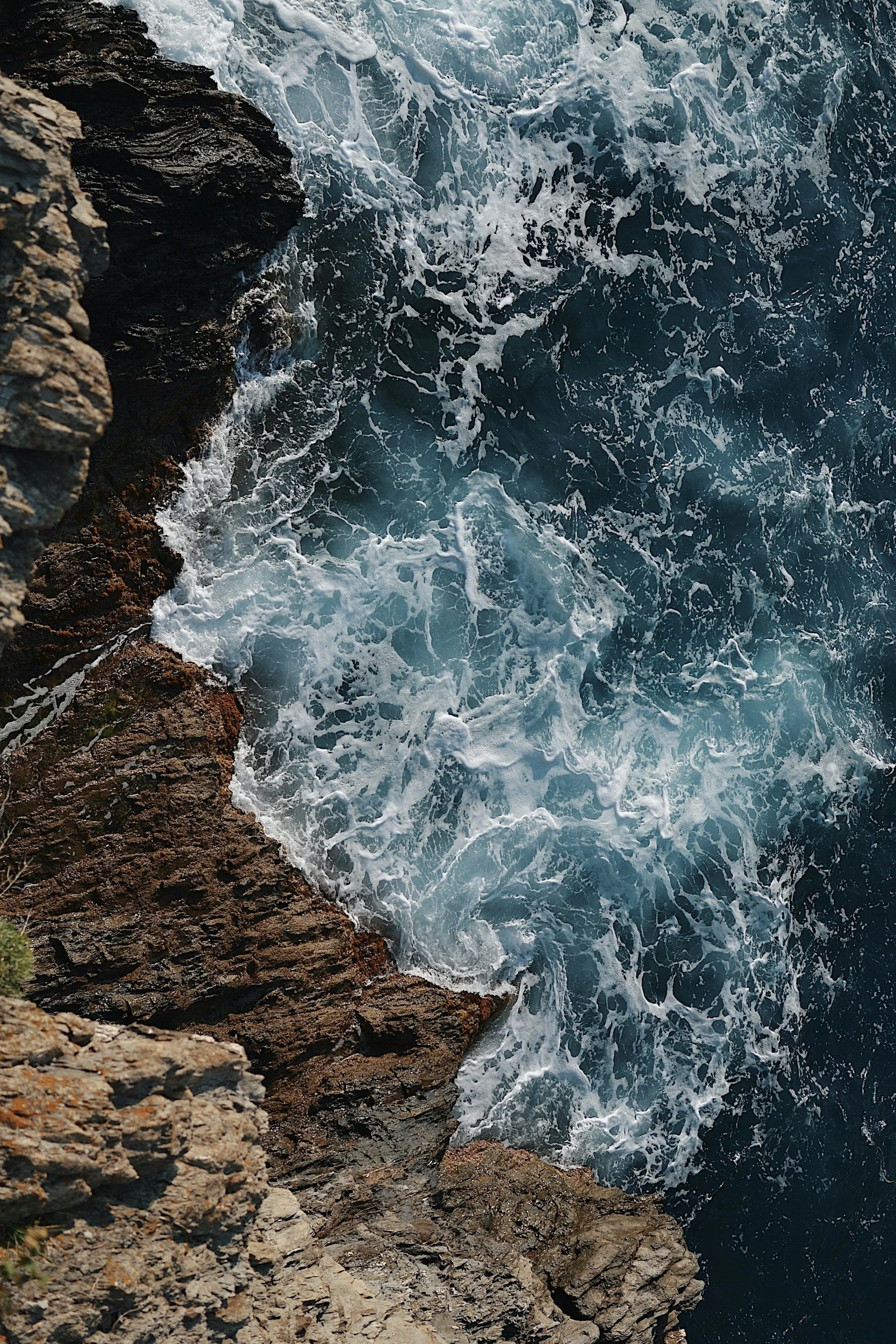 View of ocean waves crashing against rocky cliffs.