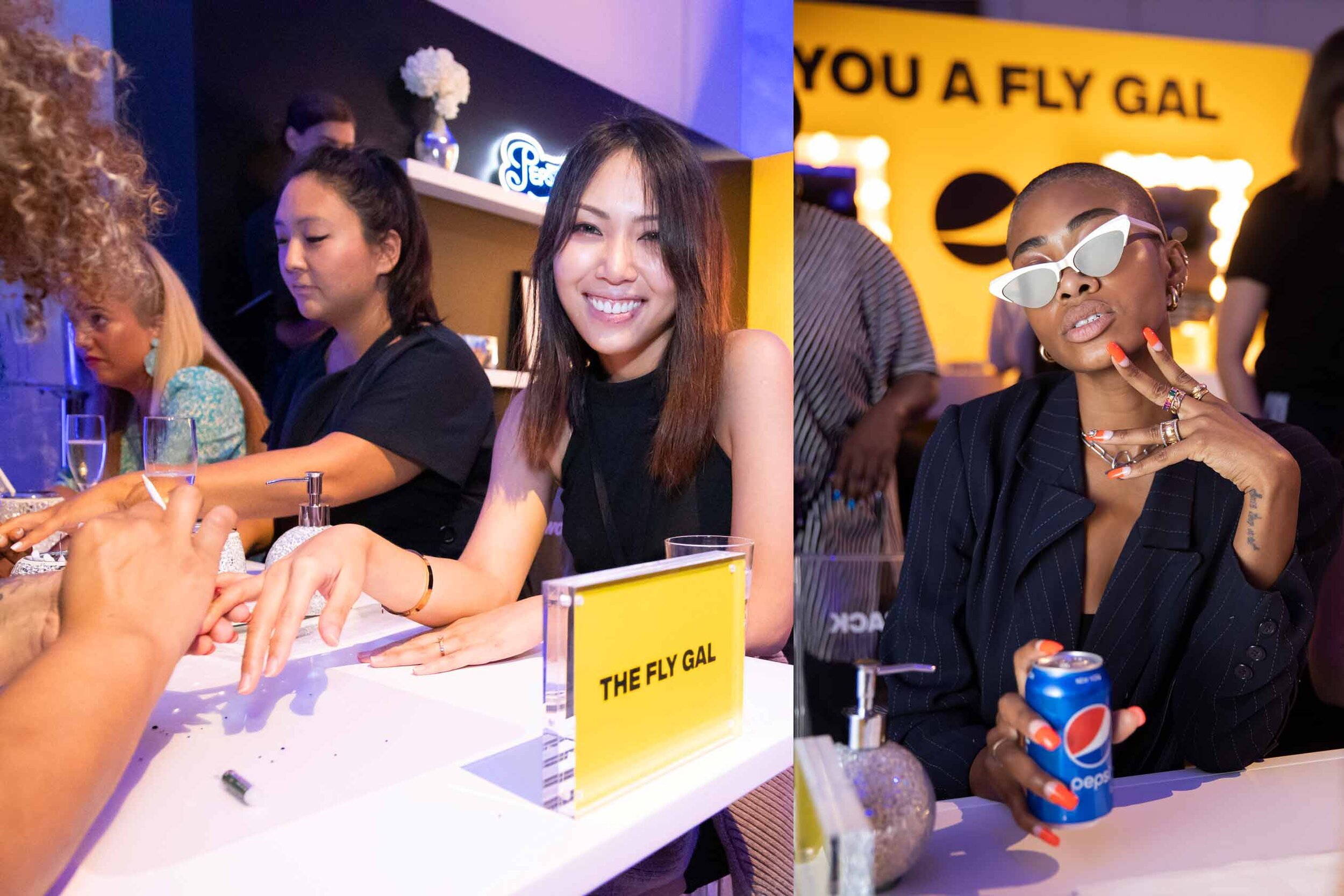 Two women seated at a registration table with a sign that reads 'The Fly Gal', with other women and people in the background, at an indoor event or party.