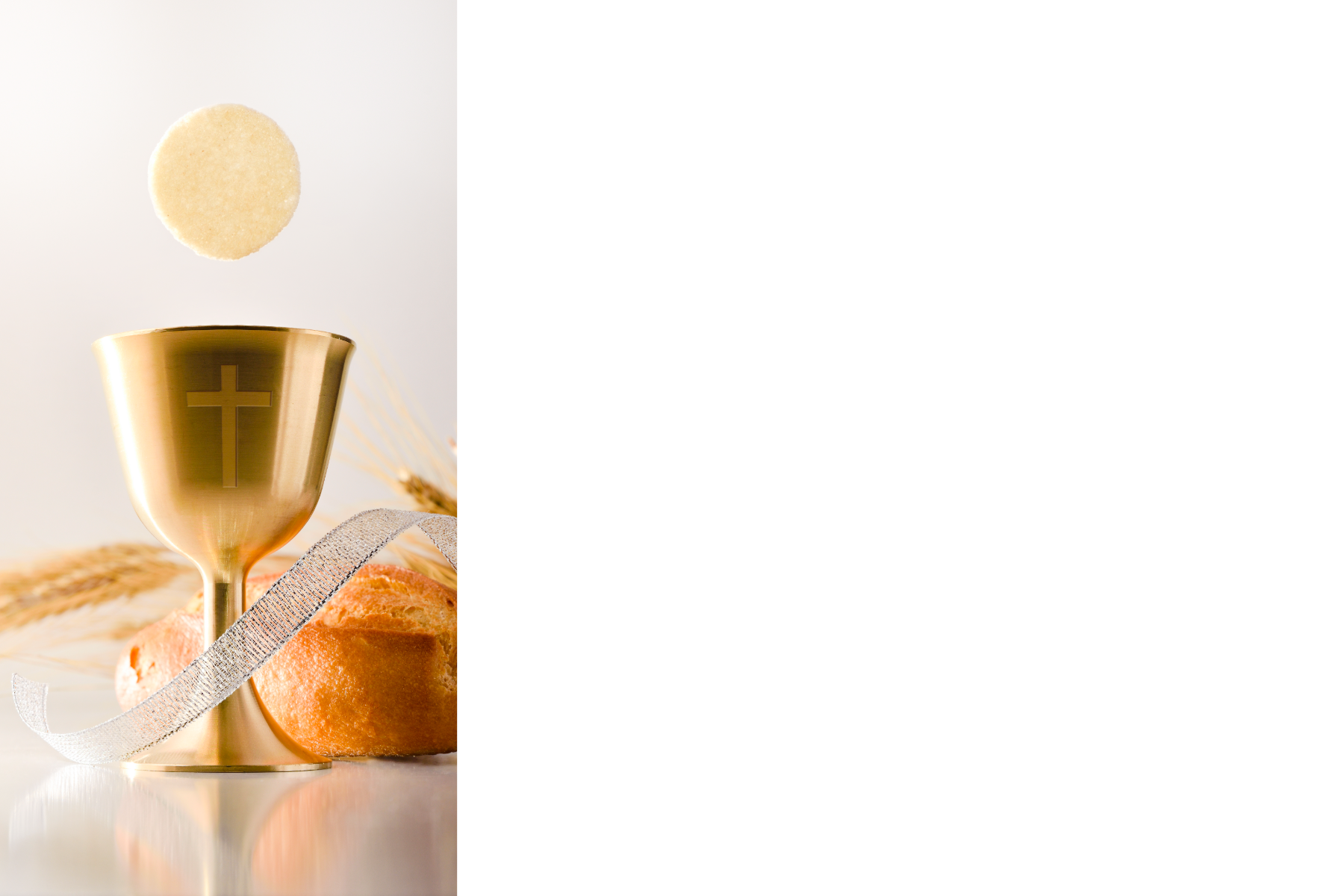 Gold communion chalice with cross, communion wafer, and bread surrounded by white ribbon