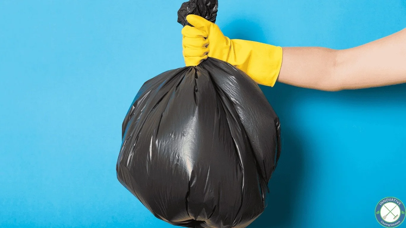 Hand grabbing a full garbage bag