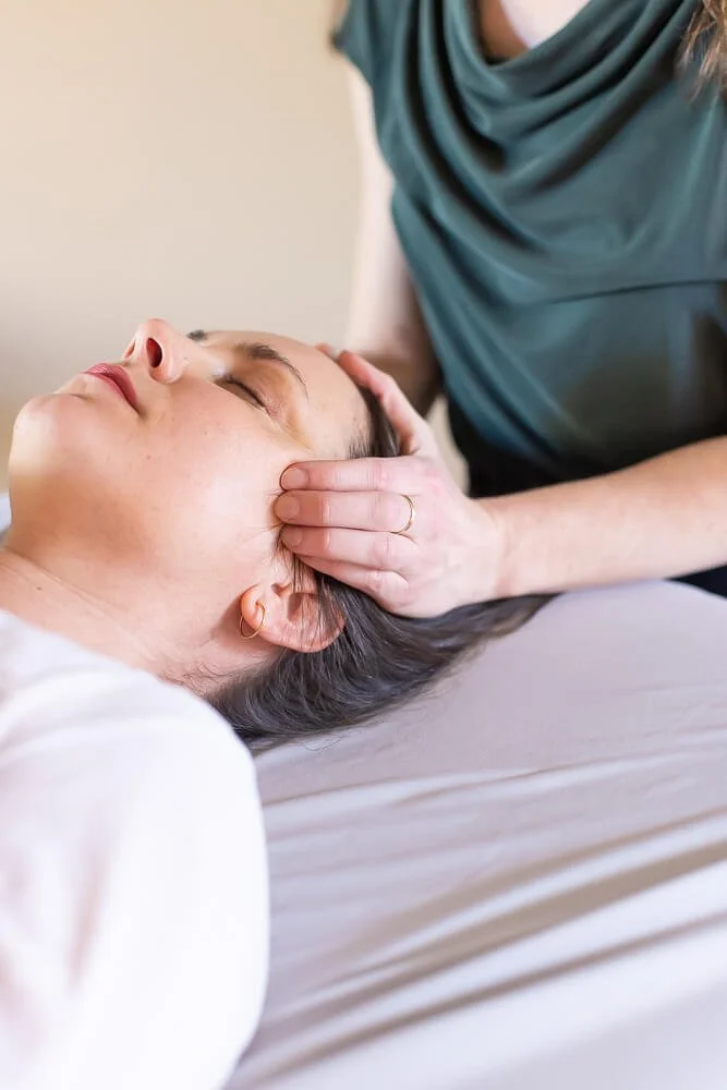 Woman receiving a head massage or scalp treatment from Jennifer Peterson at Current Wellness in Portland, Oregon.