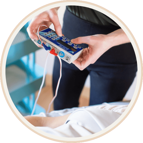 Practitioner holding a frequency specific microcurrent device during an FSM therapy session at Current Wellness Northwest in Portland, OR