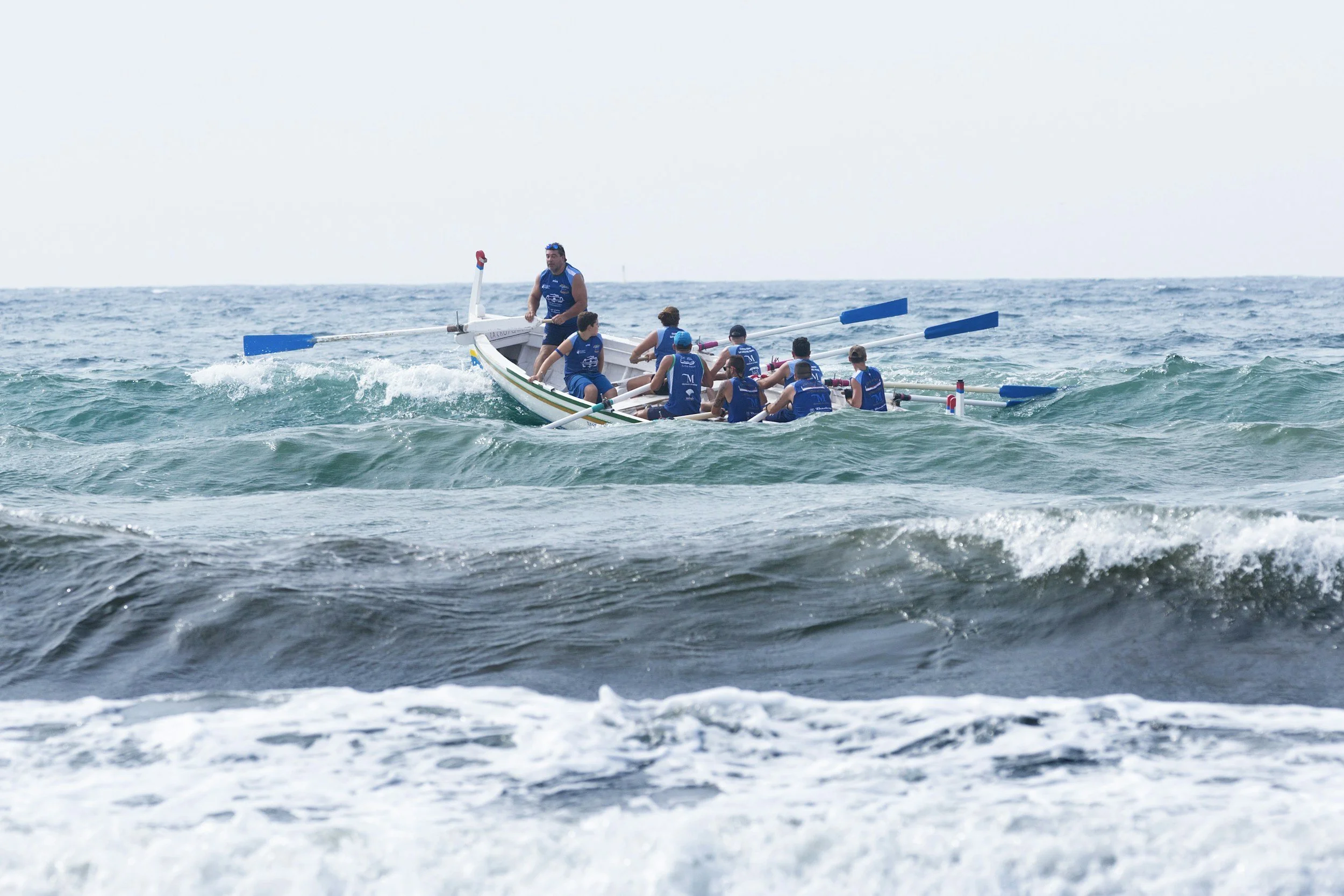 Group on large kayak working together while on ocean