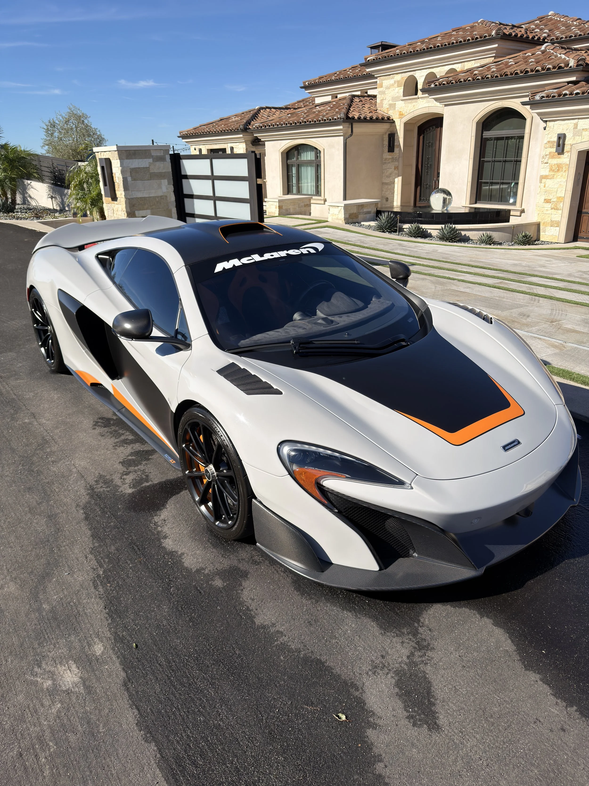 A white and black McLaren sports car just detailed on a clear day.
