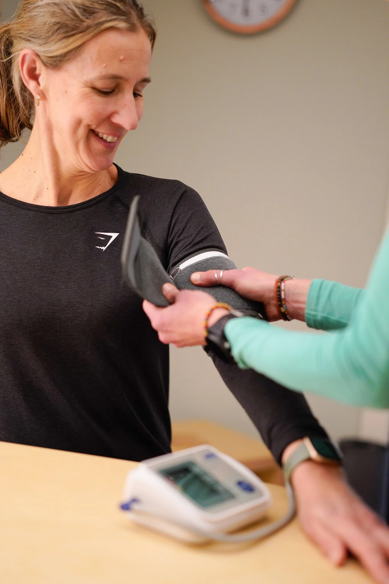 A woman wearing all black having her blood pressure taken.
