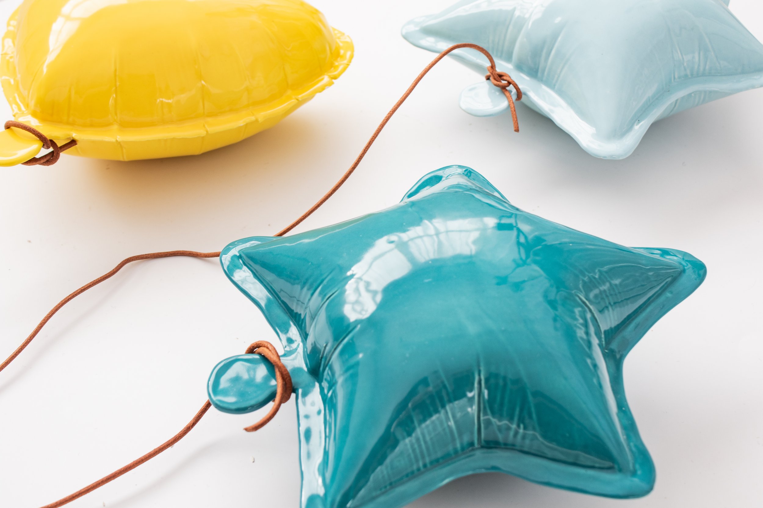 A mountain landscape with snow-capped peaks in the background and a few modern buildings on a green hillside in the foreground.