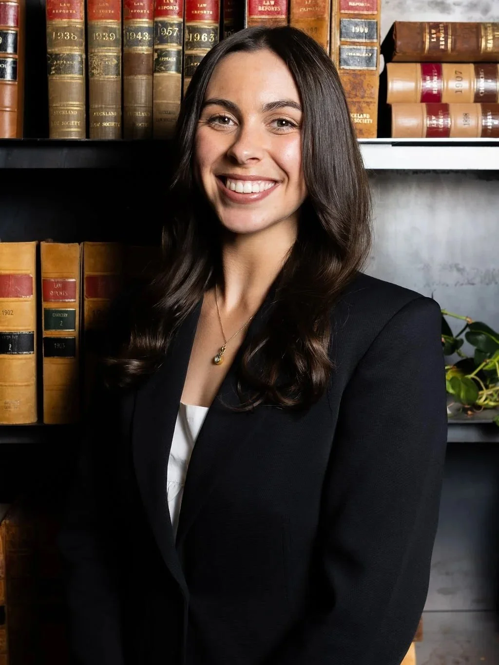 A concrete pillar with graffiti of a smiling stick figure girl flashing a peace sign, illuminated by blue and orange lighting, situated on a brick sidewalk. In the background, there are signs with German text and a metal grille on the wall.