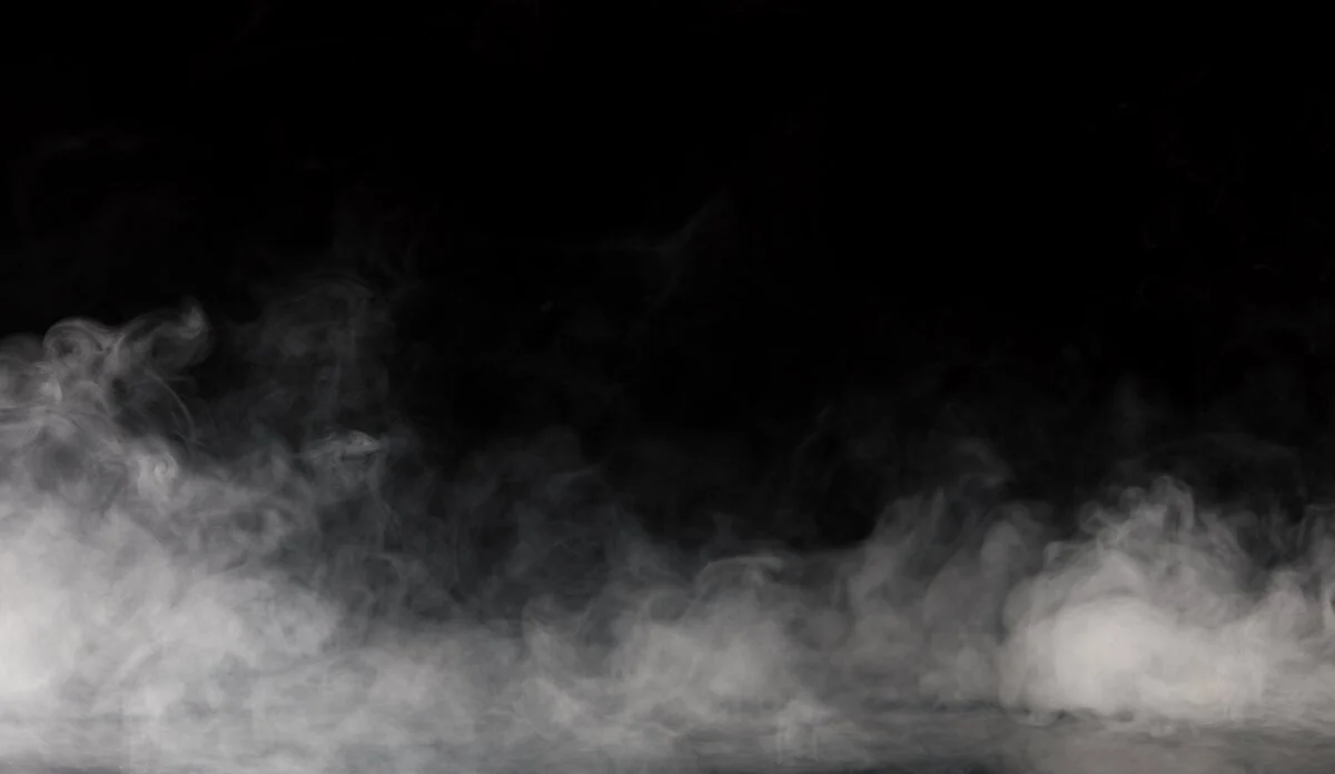 White mist or smoke rising against a black background