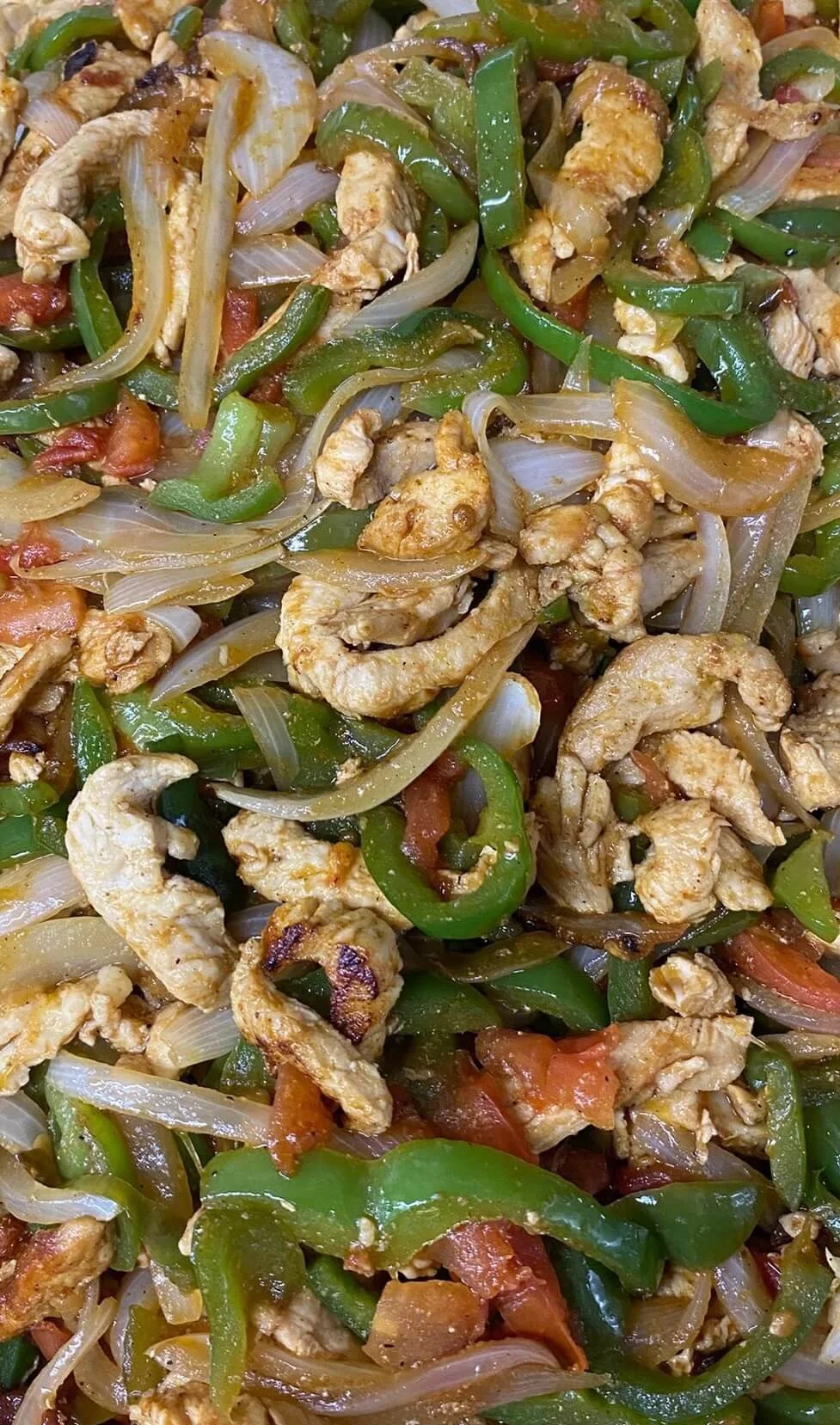 lapaisanita-starkville-fajitas.jpg → Chicken fajitas with onions, bell peppers, and tomatoes cooked on a hot grill.