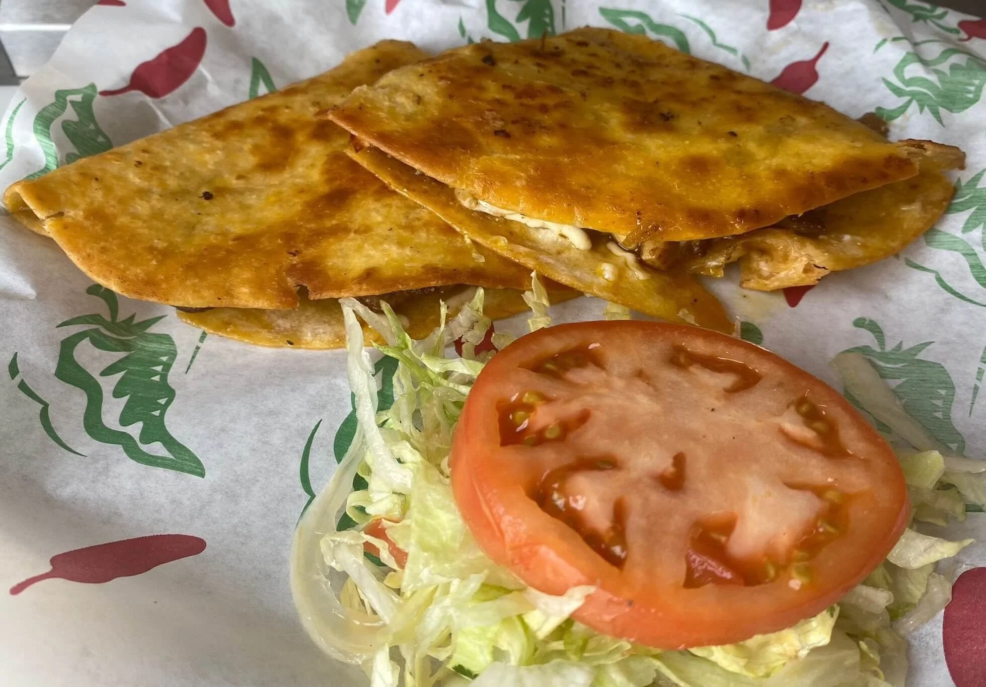 lapaisanita-starkville-quesadilla.jpg → Golden brown quesadilla with lettuce and tomato garnish 