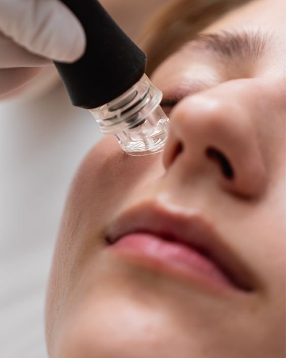 A person receiving a facial treatment with a hovering device near their nose and lips.