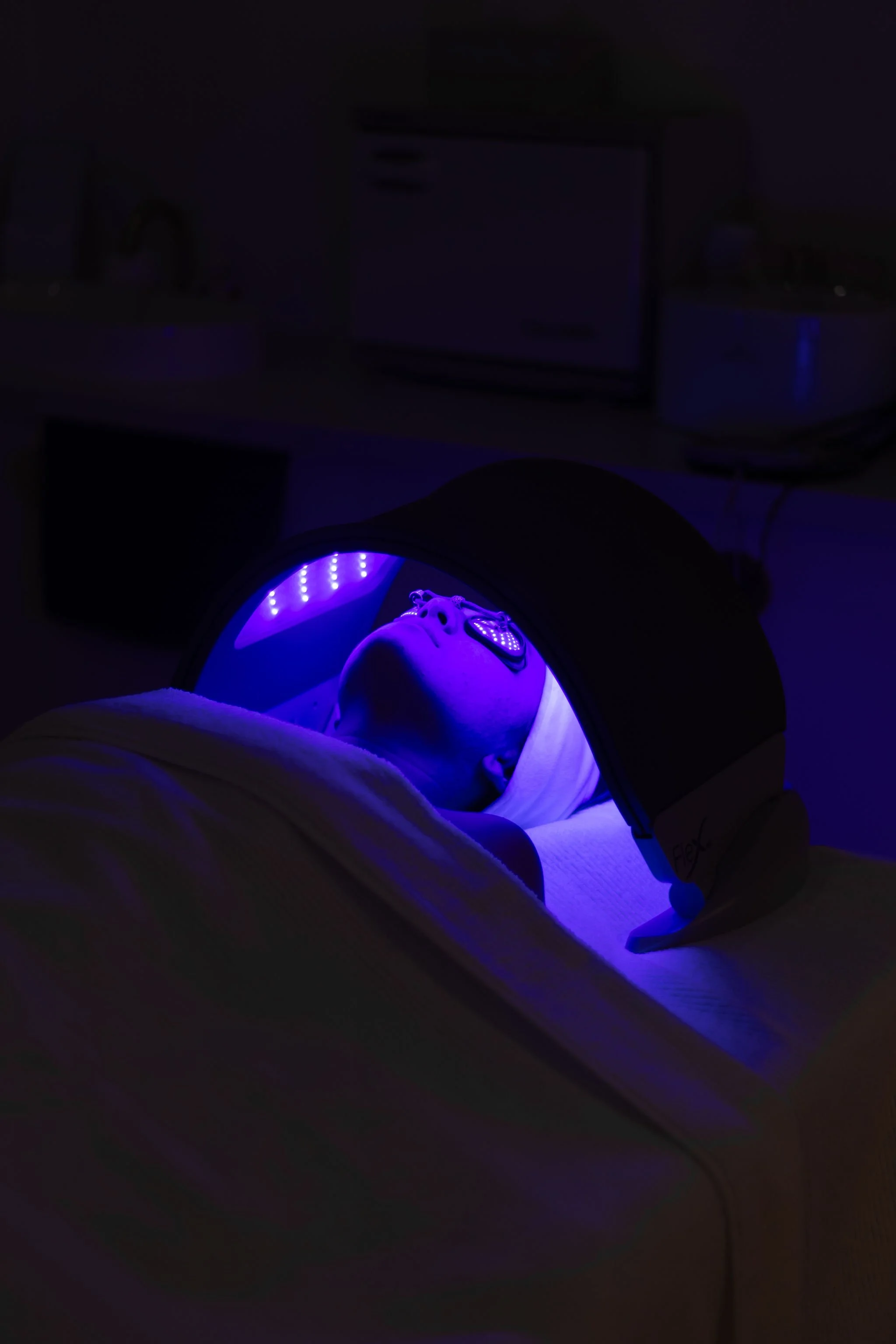 Person lying down inside an LED skin treatment machine
