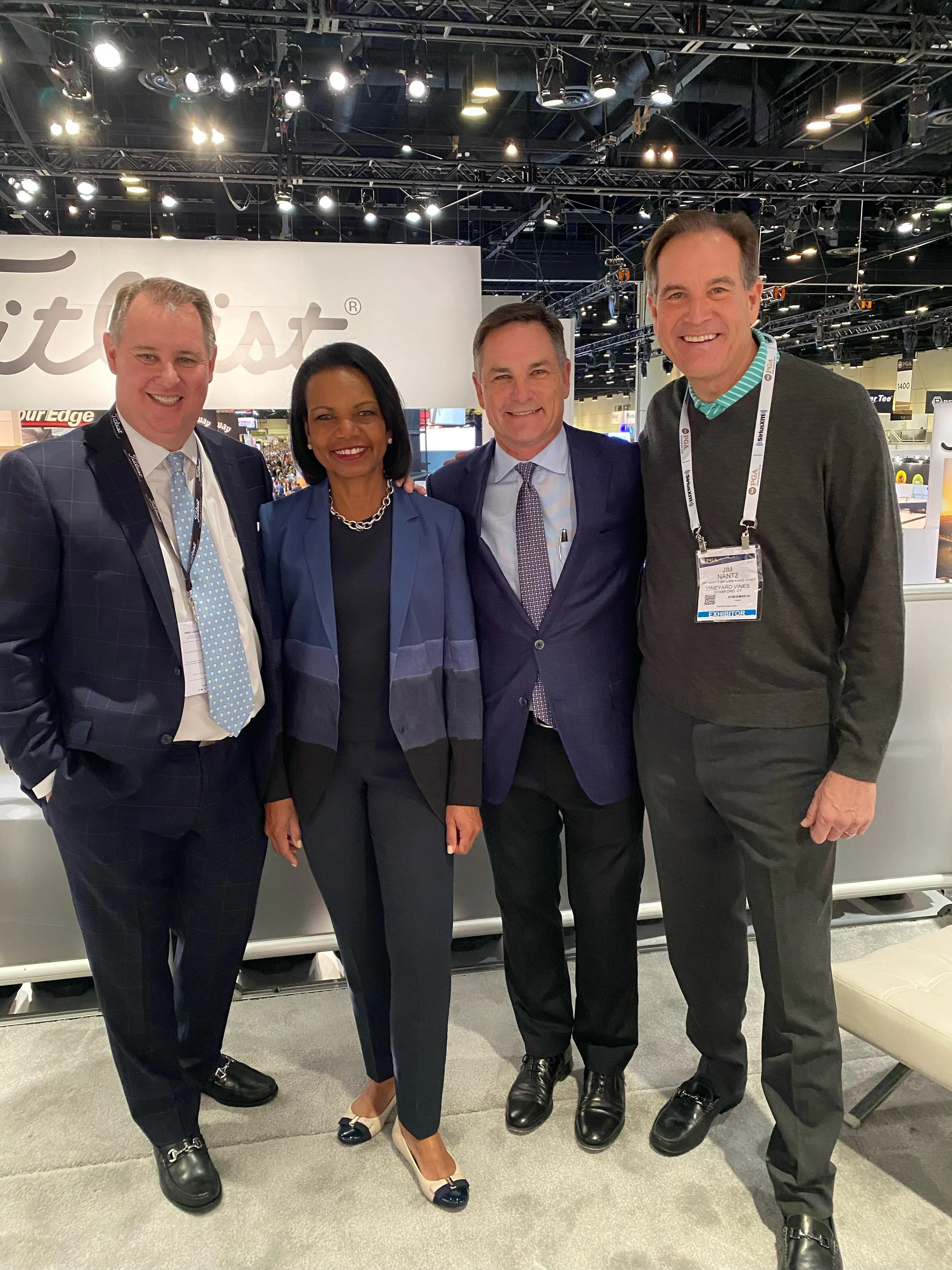 Four people standing together at a professional event, smiling for the camera, with a large white background displaying the word 'Frost' behind them.