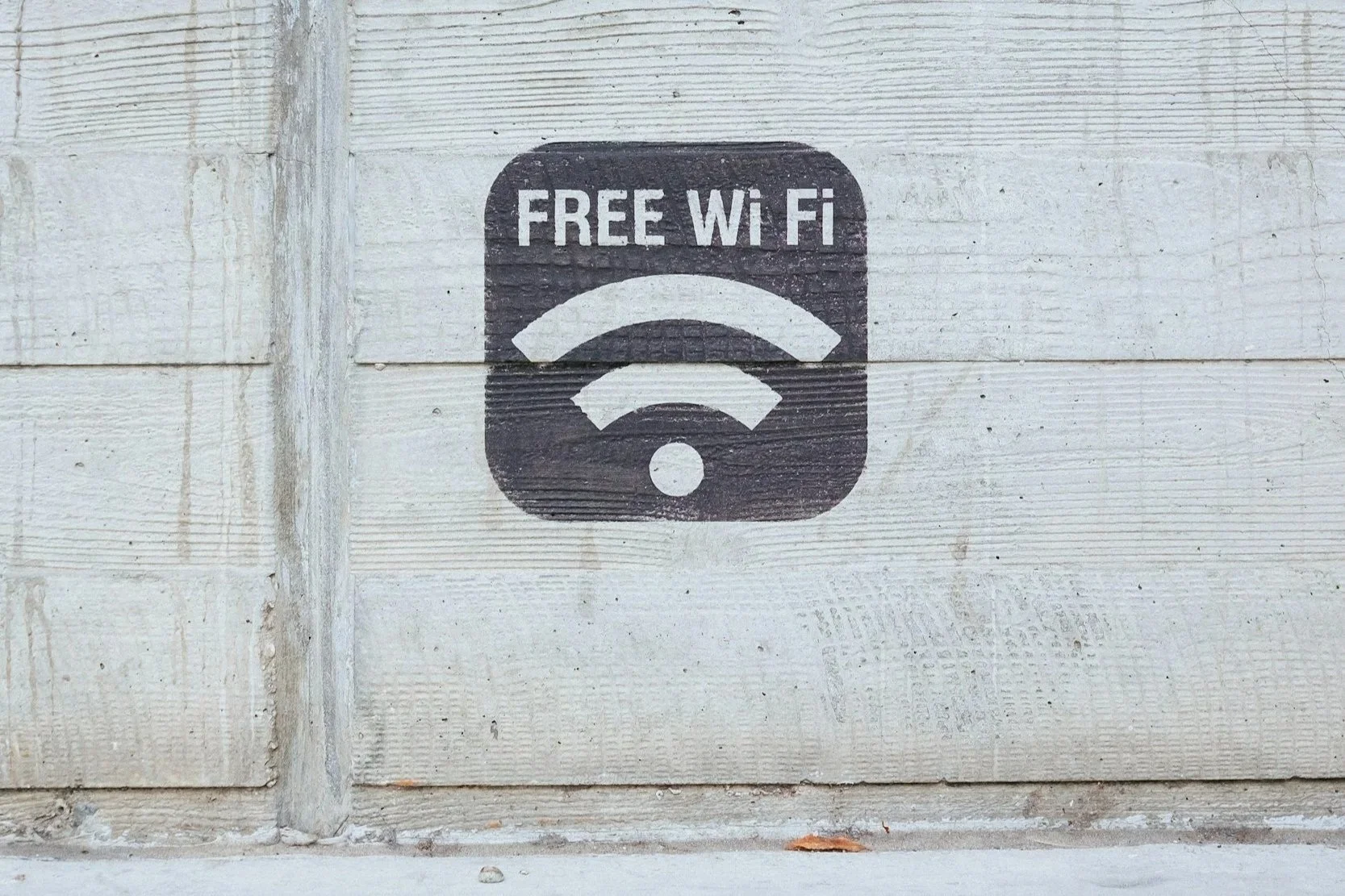 Wall with a stencil sign that reads 'FREE Wi Fi' above a Wi-Fi symbol.