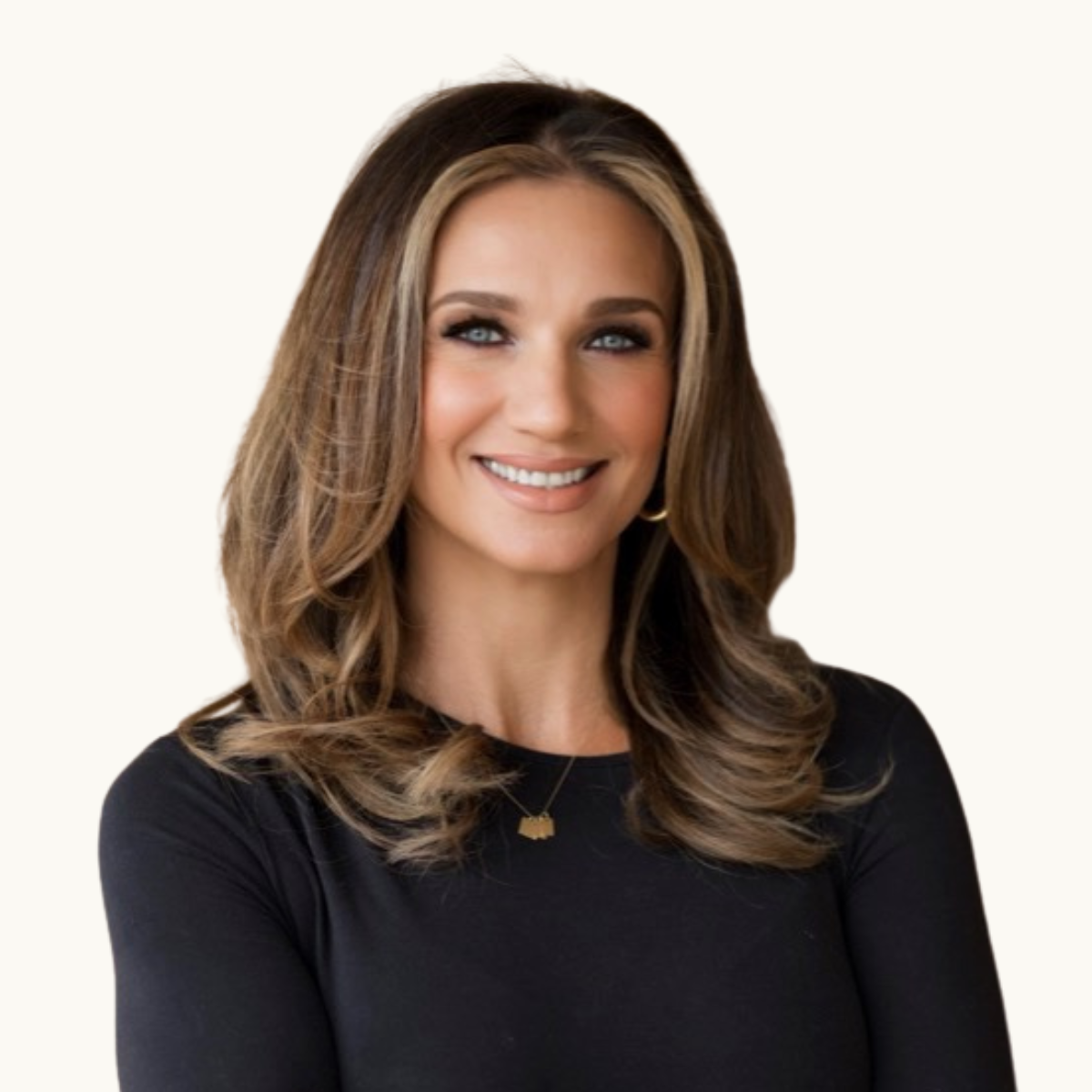 Portrait of a smiling woman with wavy brown hair wearing a black top and a gold necklace, against a light background.