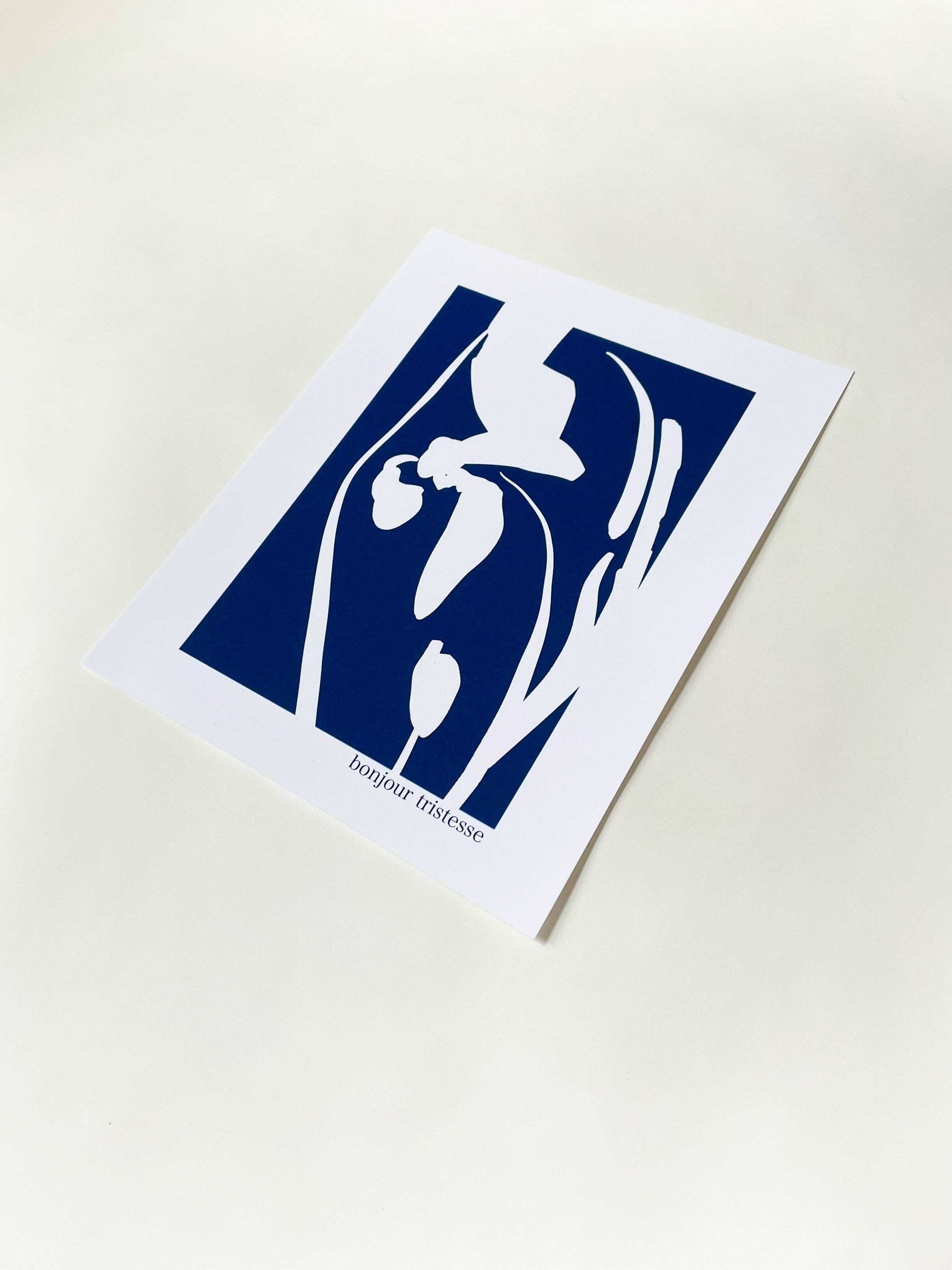 Une affiche avec un dessin stylisé d'une ampoule blanche et d'une fleur stylisée, en blanc sur fond bleu, avec le texte "bonjour tristesse" en bas.