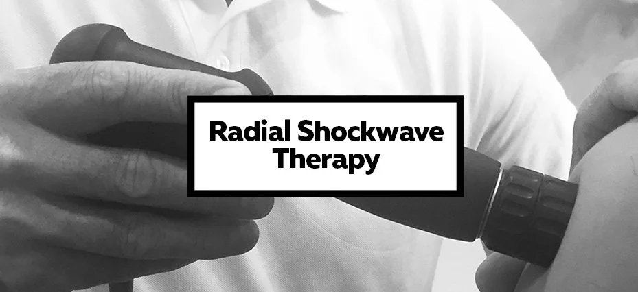 Close-up of a hand holding a device used for Radial Shockwave Therapy on a patient.