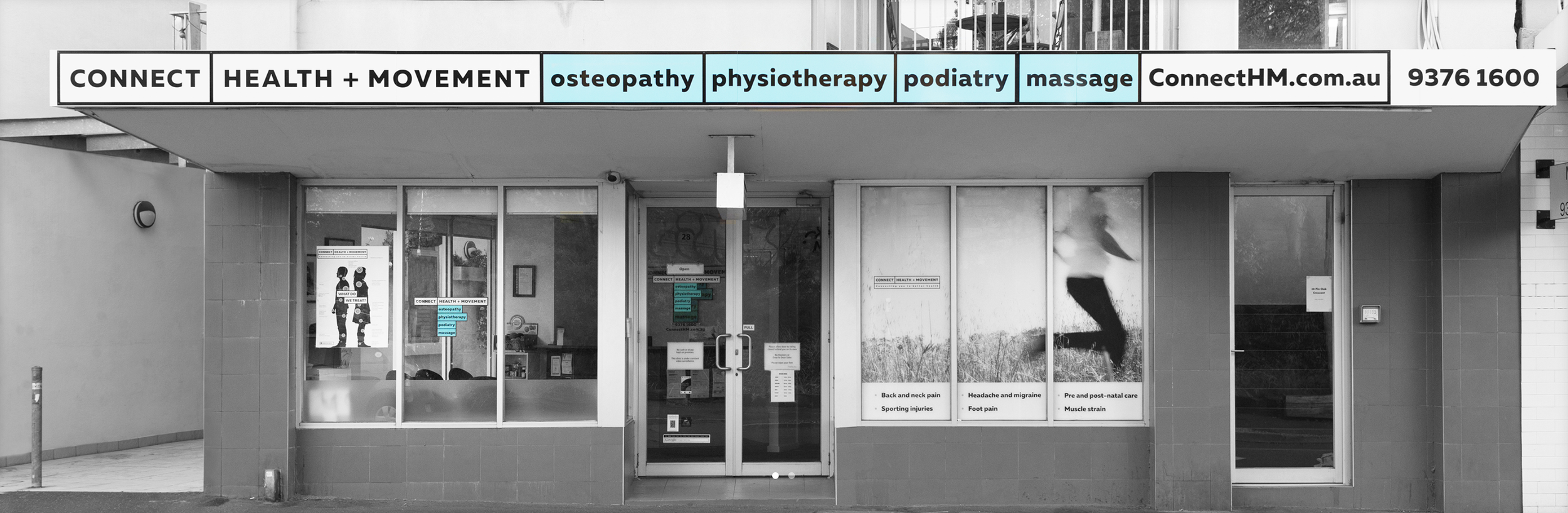 Front view of a health and movement clinic with signage offering osteopathy, physiotherapy, podiatry, and massage services, including contact details and a website.