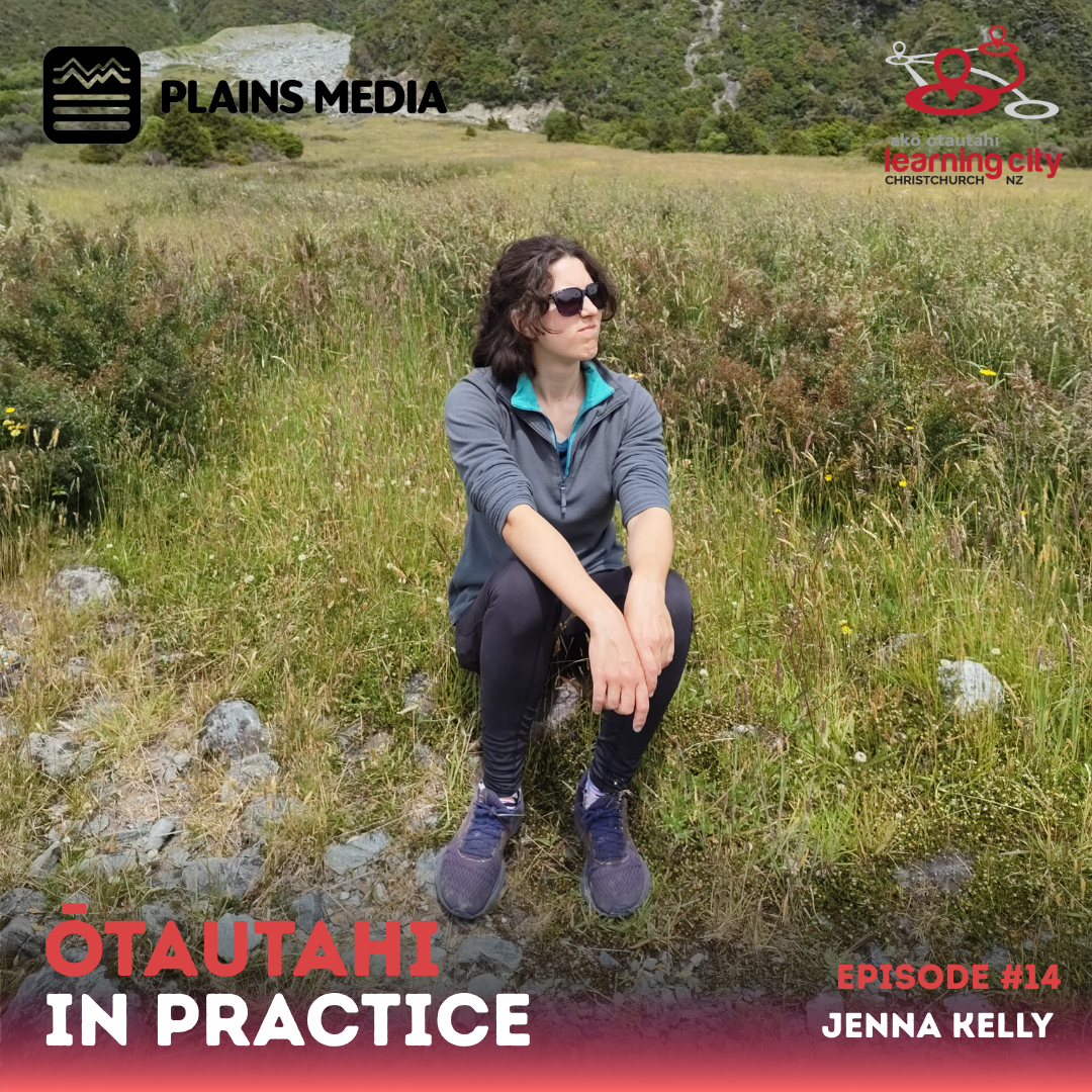 Jenna looks into the distance while sitting on the ground with a lush grass background