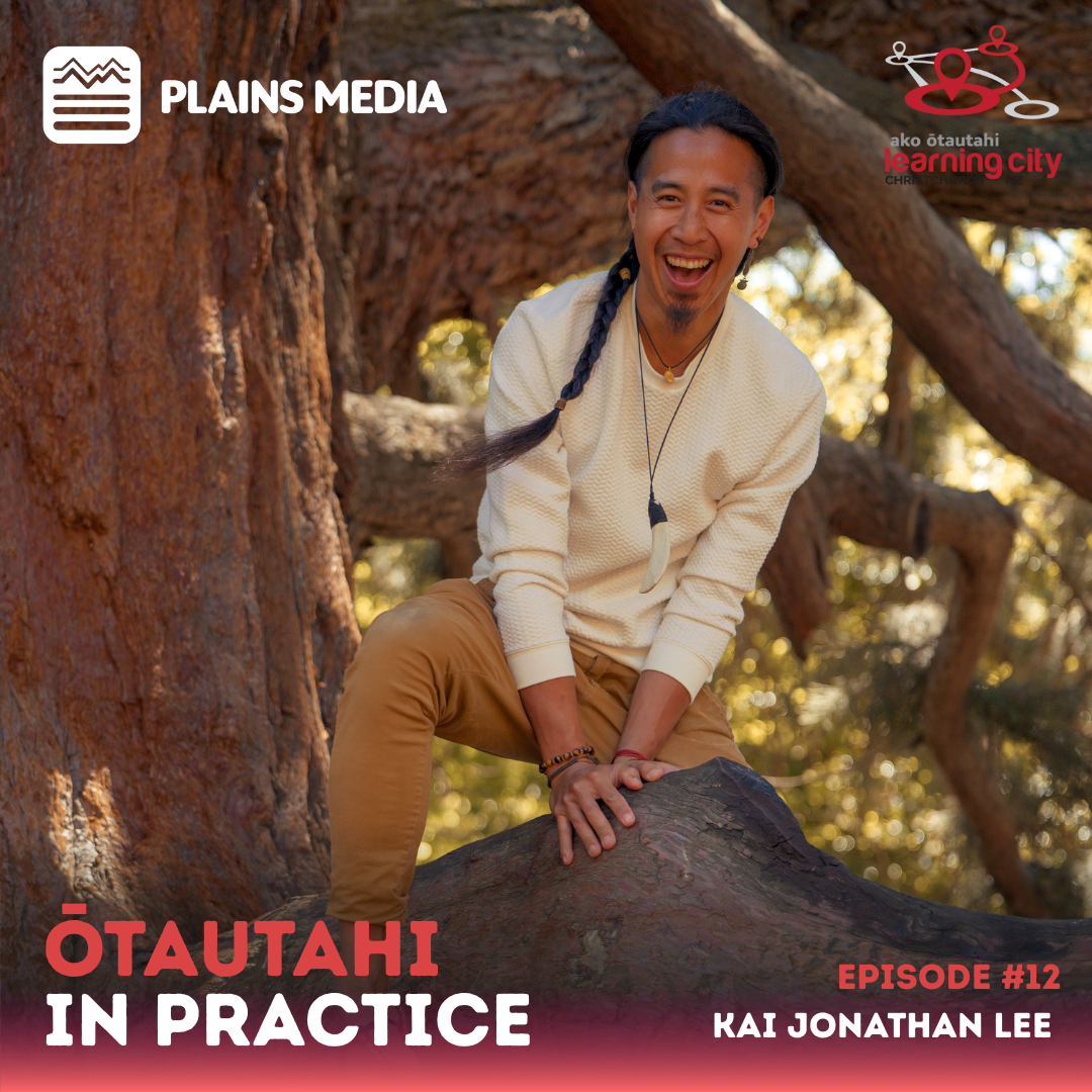 Kai smiles at the camera while perched in a tree