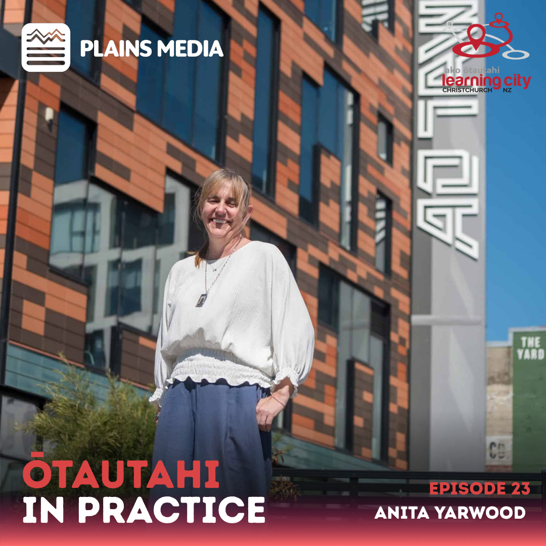 Anita looks down at the camera with the Ao Tāwhiti school building in the background.