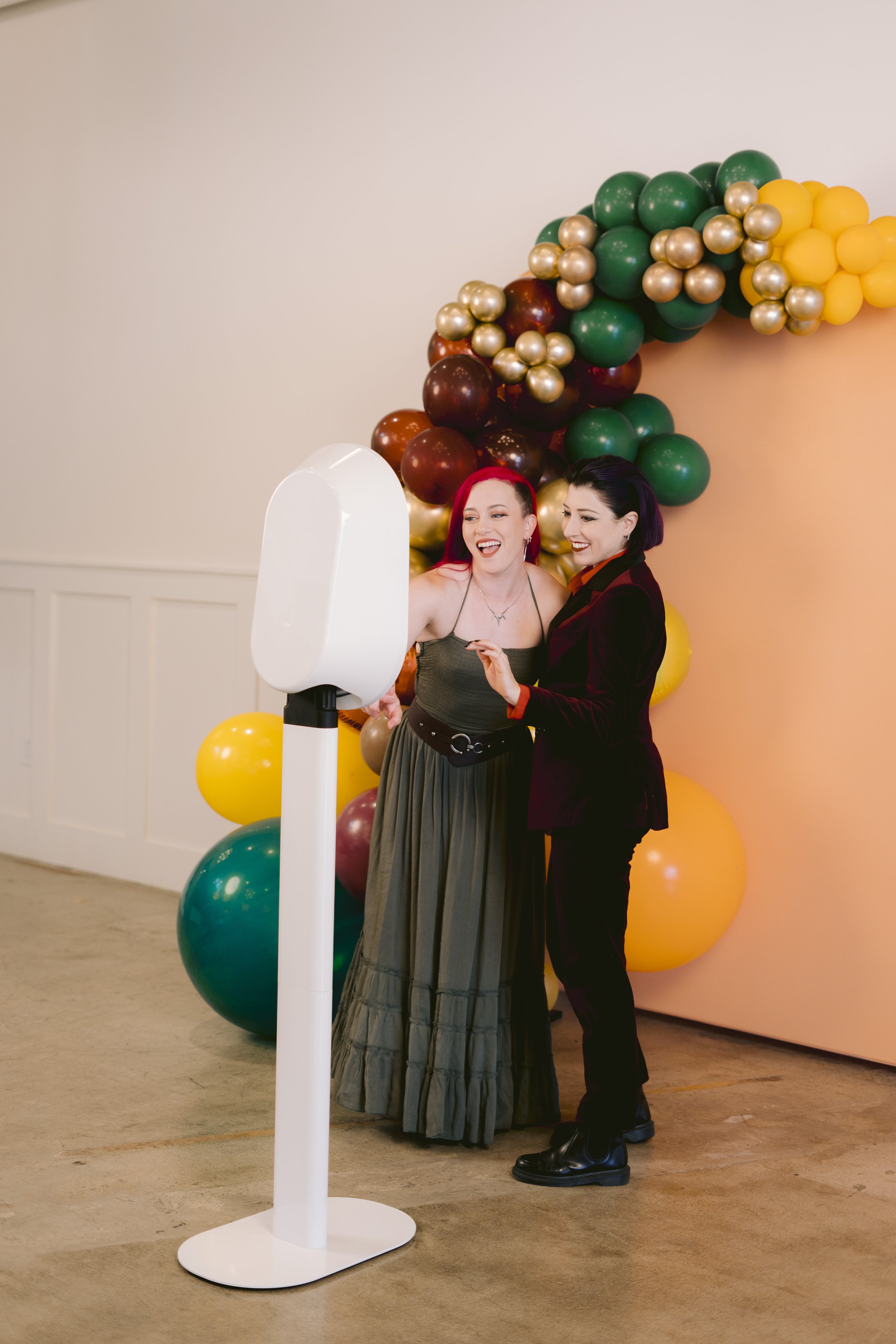 Two guests using a photo booth rental with backdrop at a private event in Berkshire County, Massachusetts