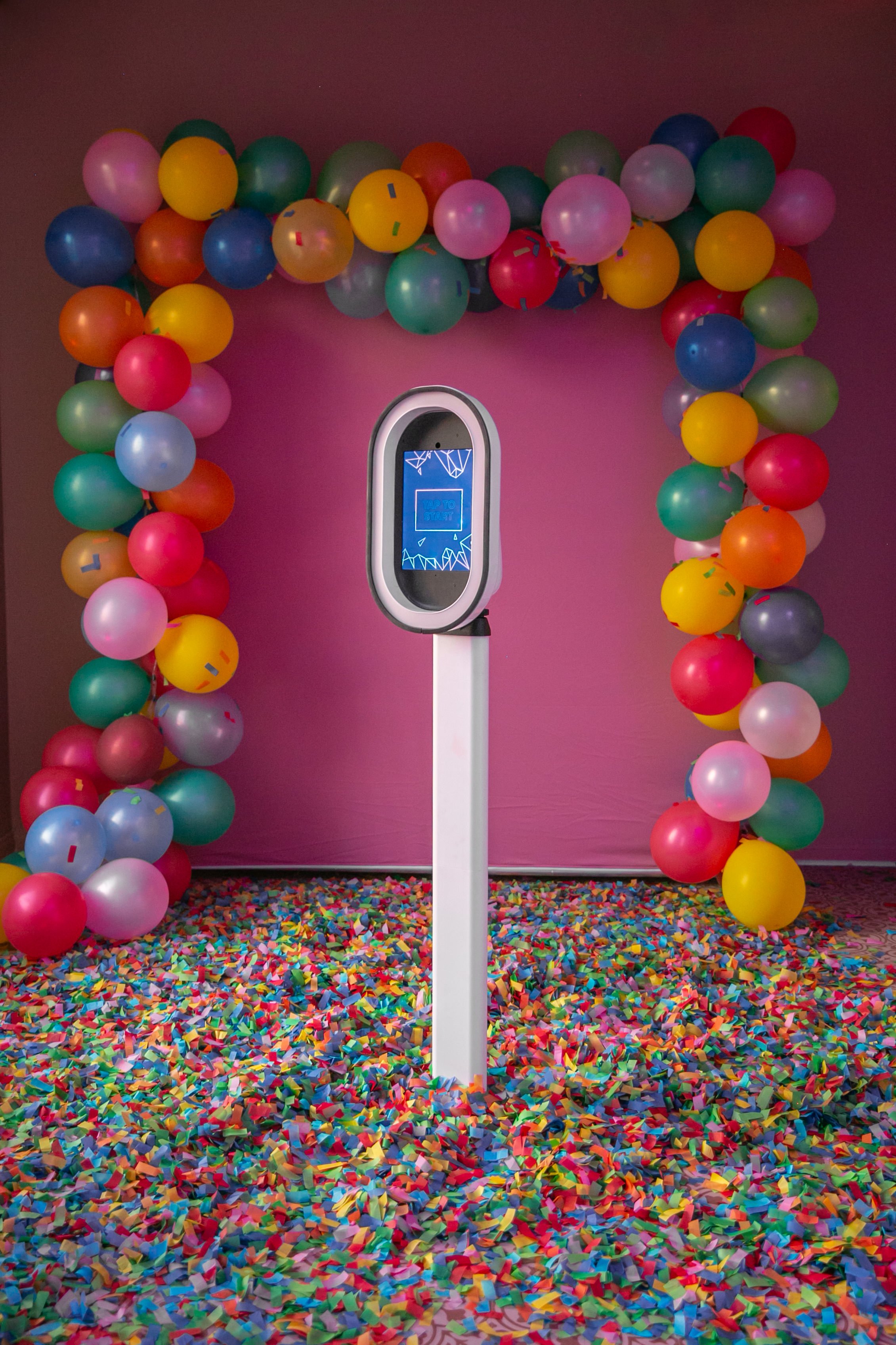 Modern white photo booth rental displayed at an event with balloon decor in Berkshire County, Massachusetts