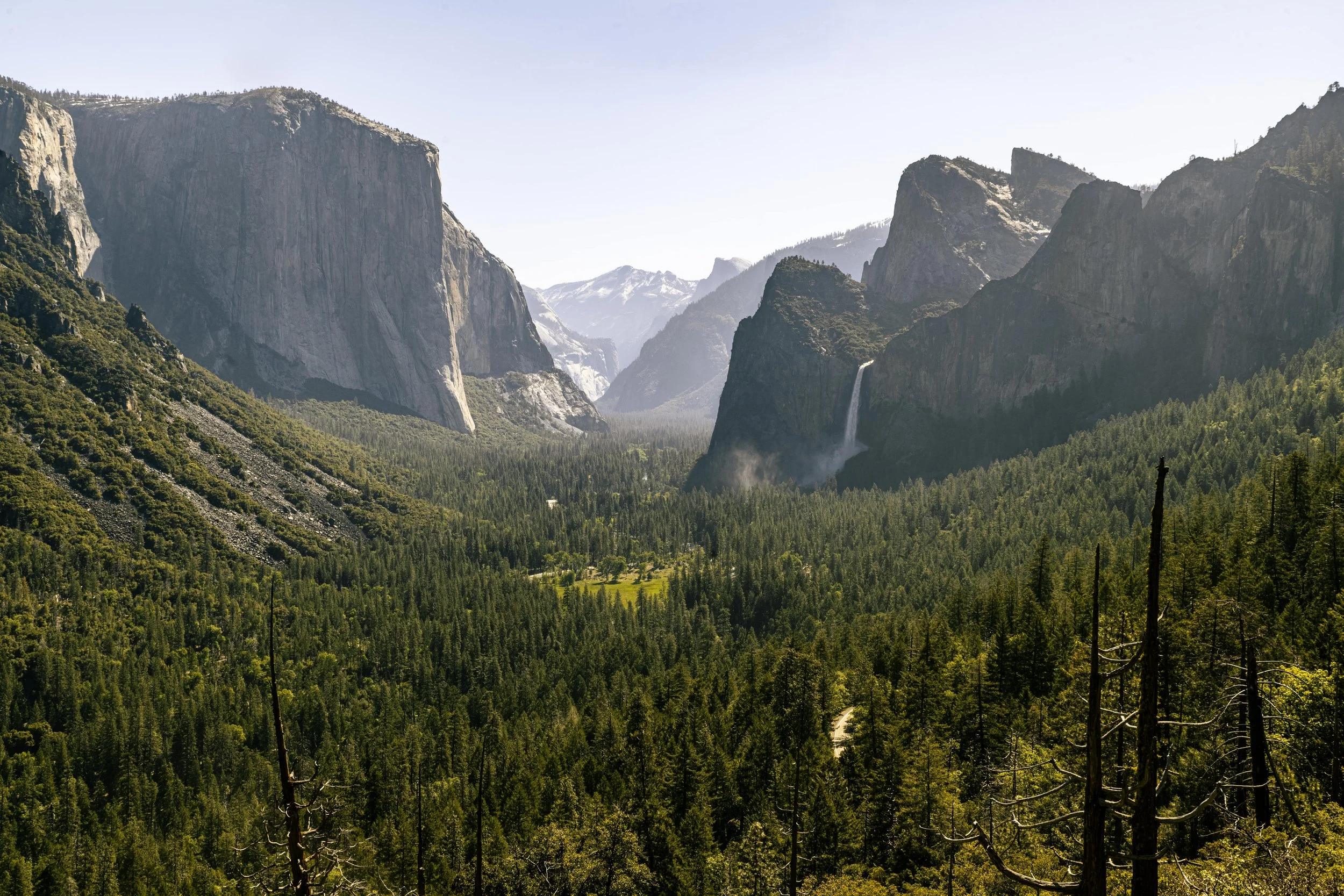 A scenic view Yosemite Valley, including Bridalveil Falls flowing down the mountains.