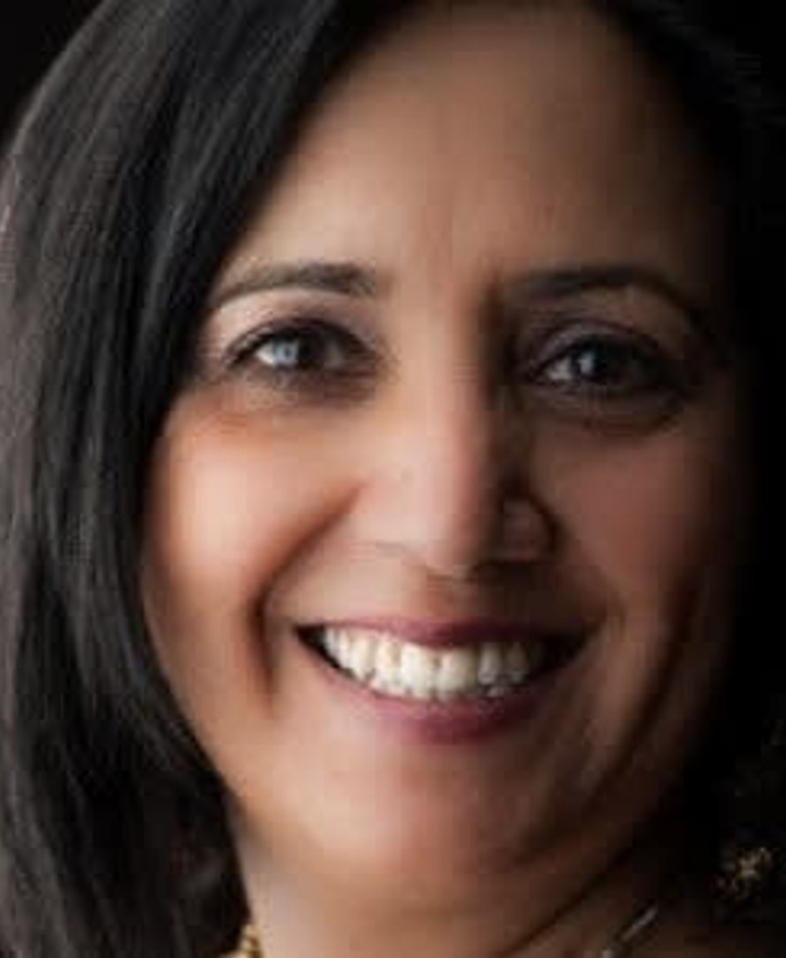 Close-up of a woman with dark hair smiling at the camera.
