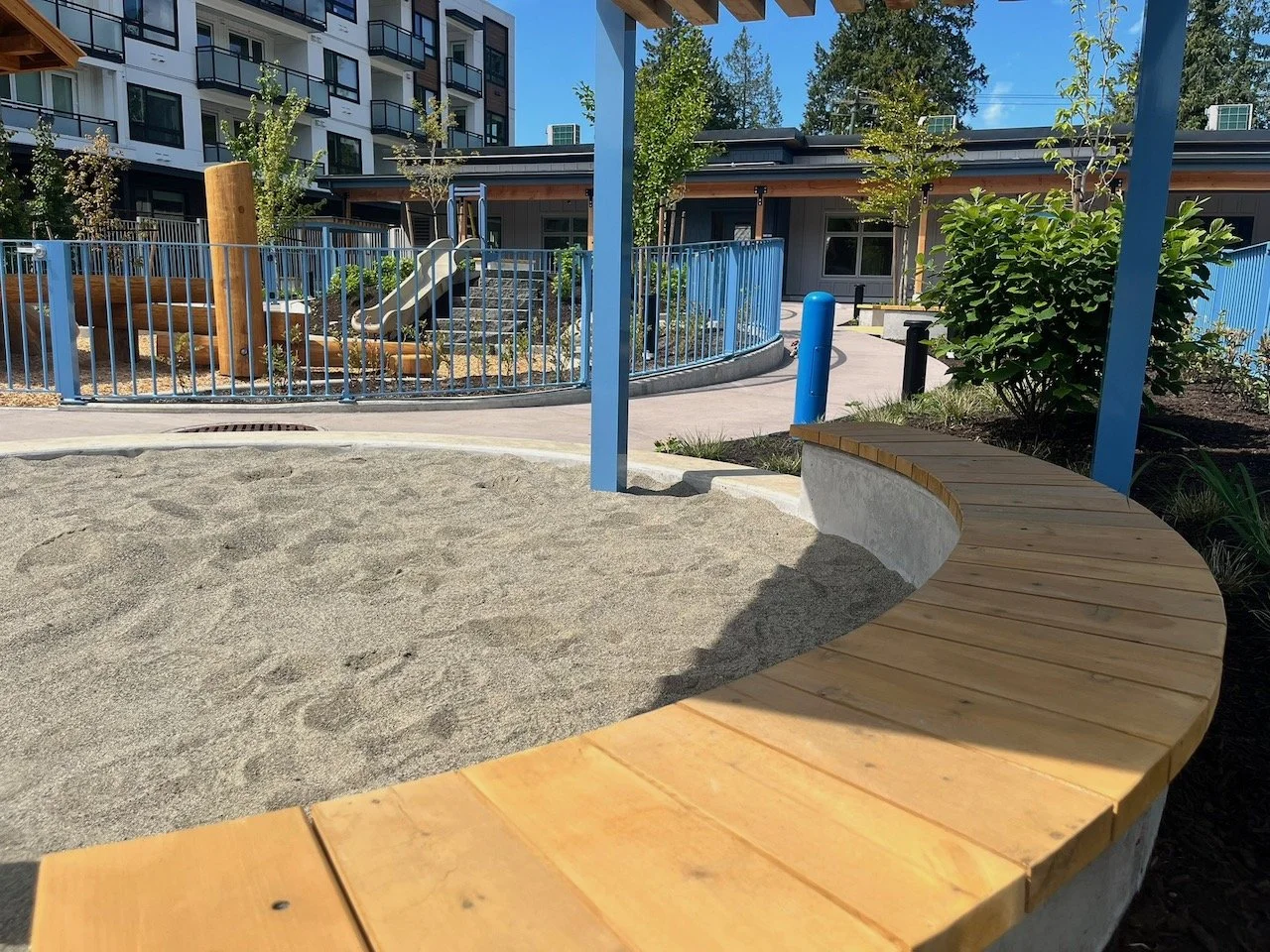 Sandbox with bench and slide in the background
