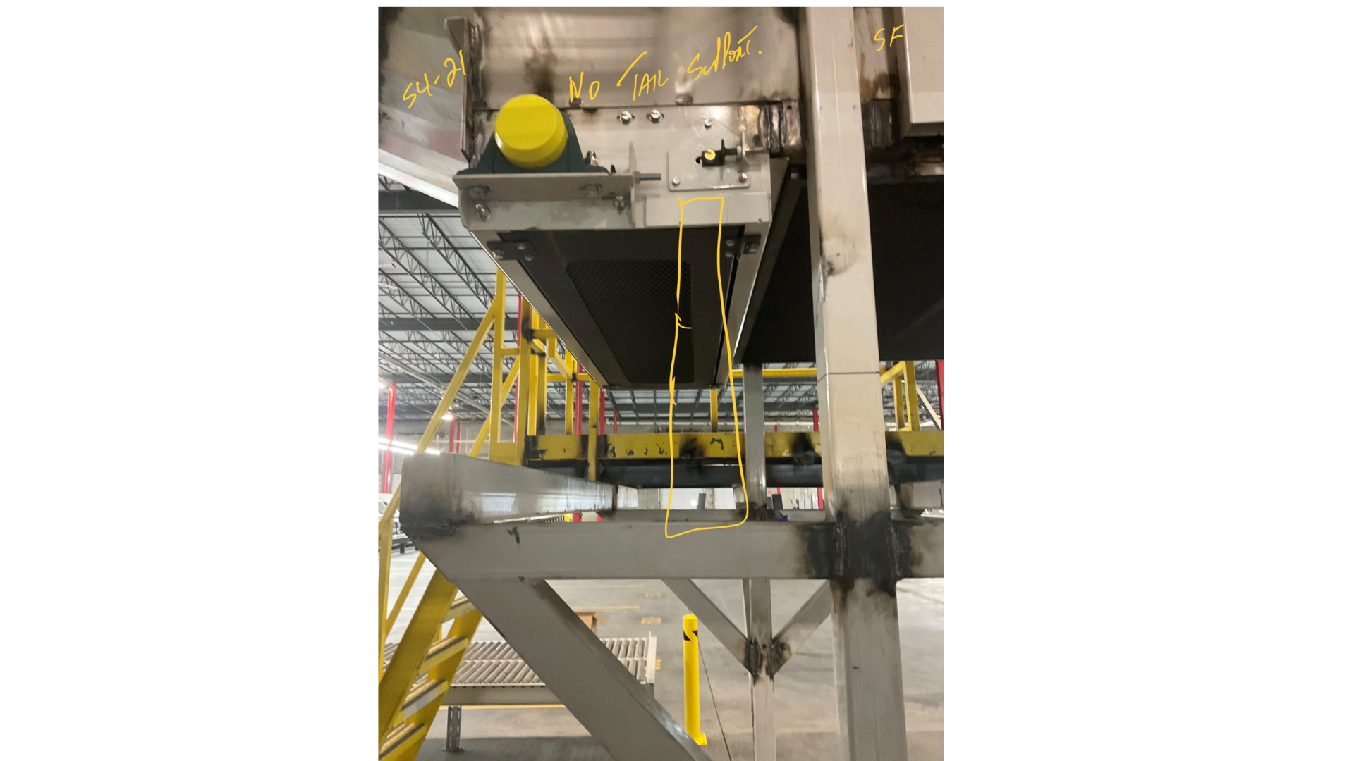 Industrial equipment with handwritten notes including yellow wires and metal structures, in a factory setting.