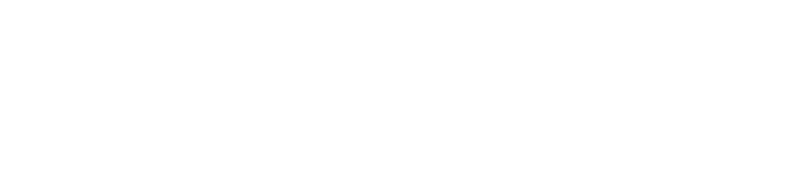 A close-up of white ceramic cups and saucers stacked on a wooden table, with a cloth napkin nearby.