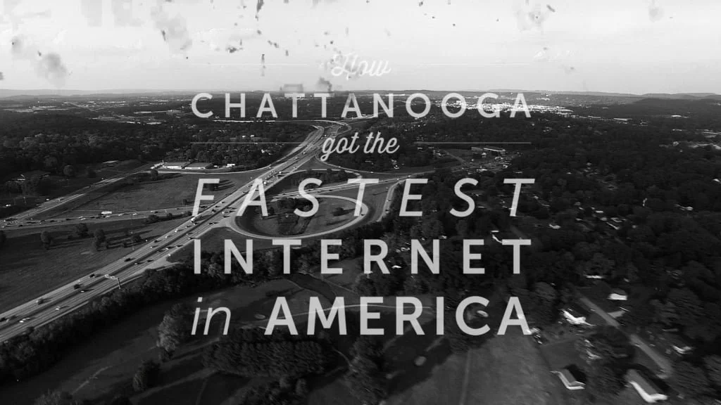 Black and white aerial view of a highway interchange in Chattanooga, Tennessee, with overlay text reading 'How Chattanooga got the fastest internet in America'.