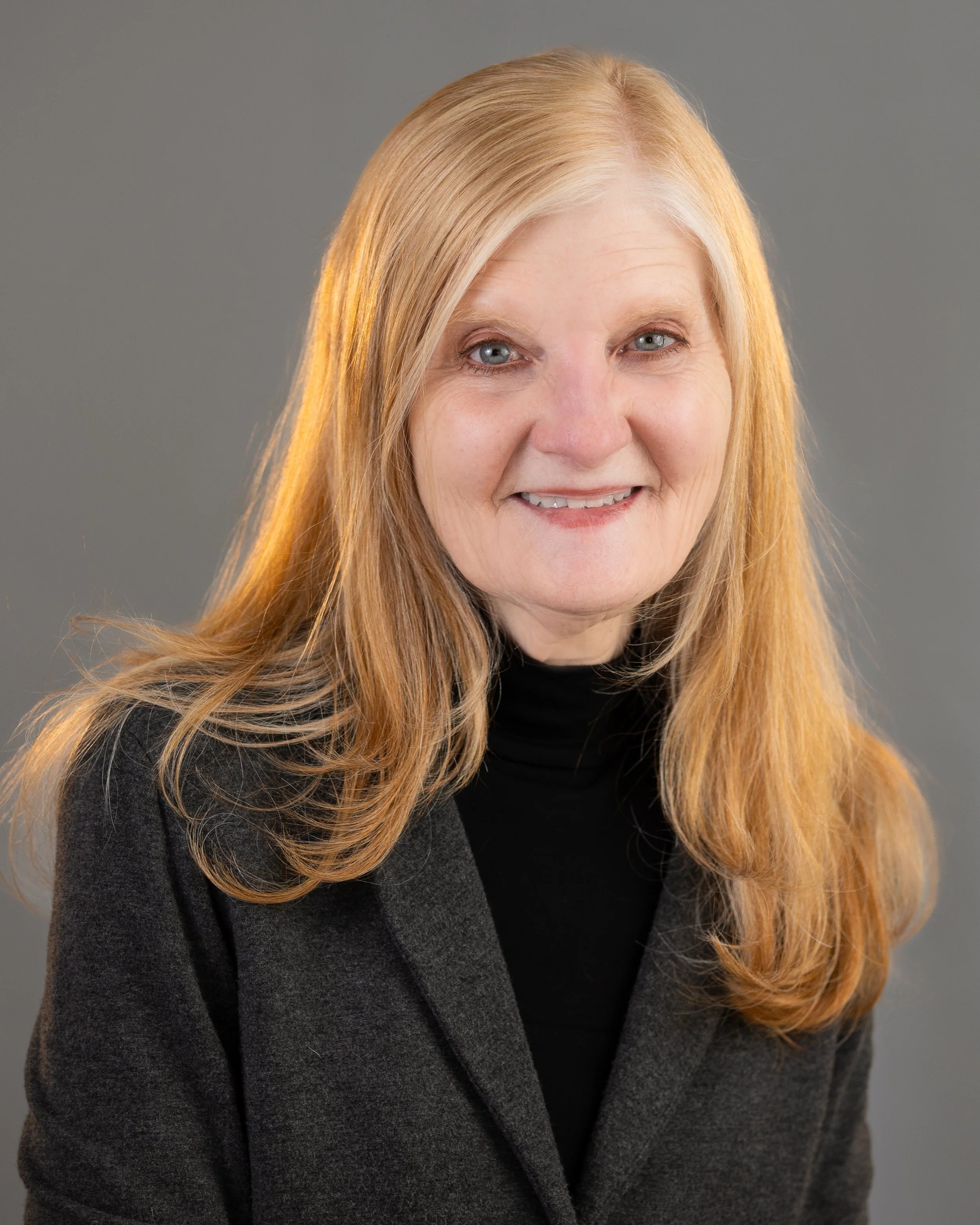 Women in grey blazer smiling professionally