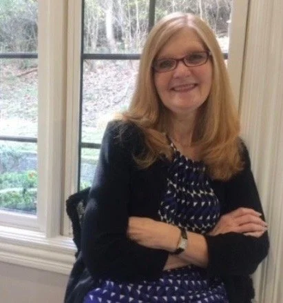 Women in black sweater with arms crosse smiling