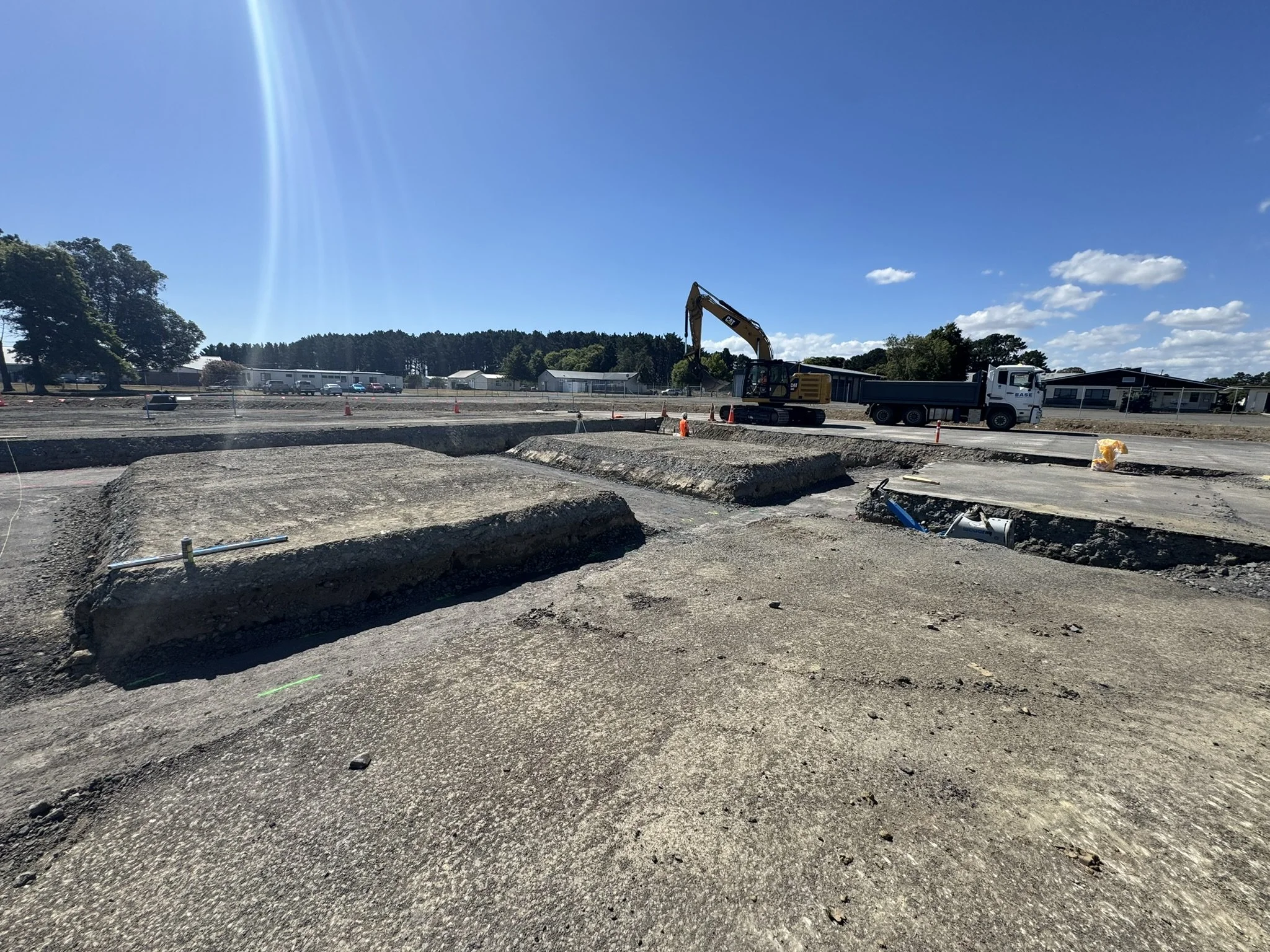 Construction site with excavator and truck under a blue sky