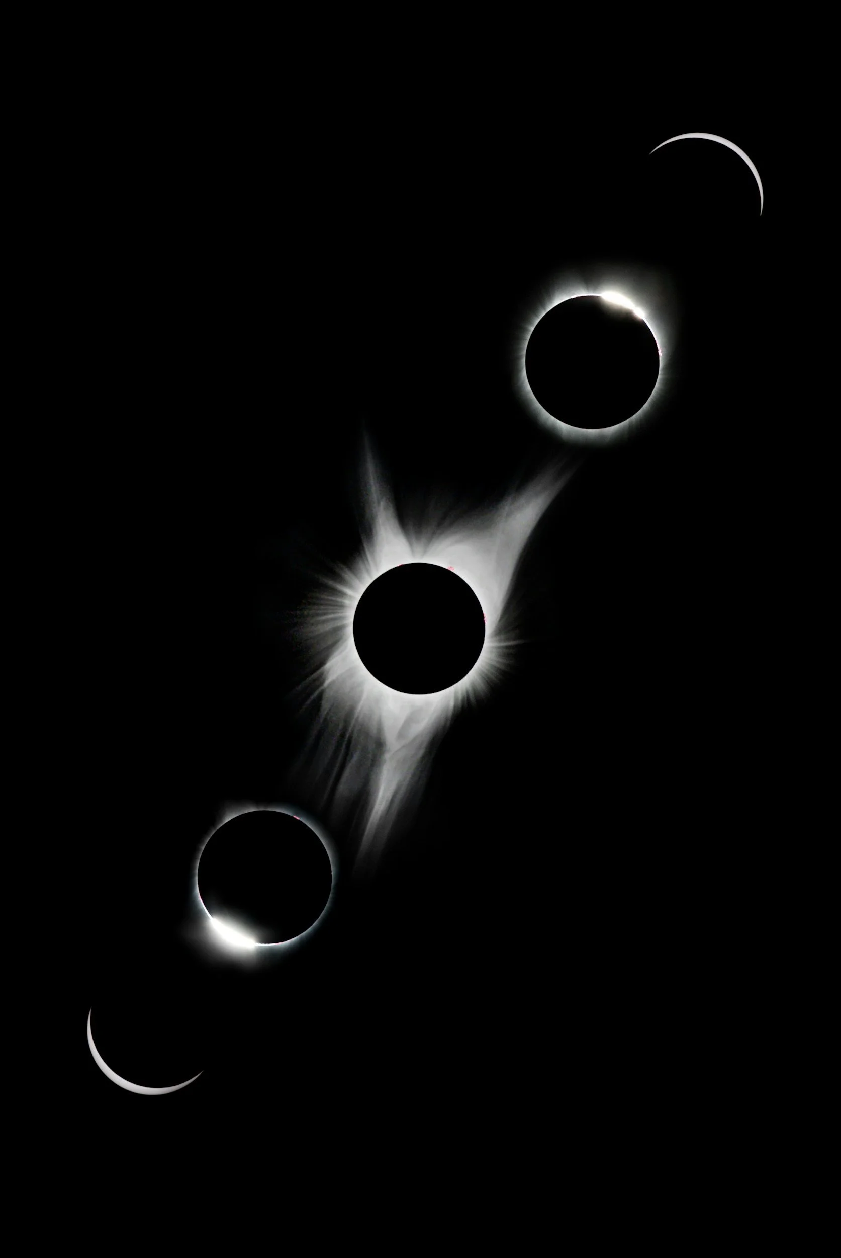 Sequence of four solar eclipse phases showing the moon covering the sun, with a ring of sunlight around the moon at the peak, set against a dark sky.
