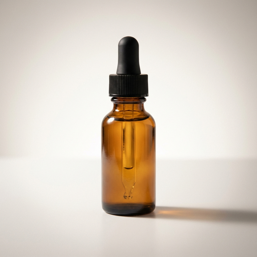 An amber glass dropper bottle with a black cap and rubber bulb on a white background.