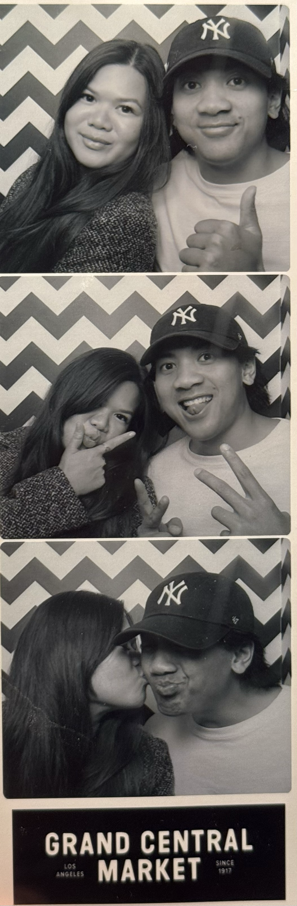 Three black-and-white photo booth pictures of a young couple posing and having fun, with a chevron-patterned background, and a sign reading "Grand Central Market, Los Angeles, Since 1917."