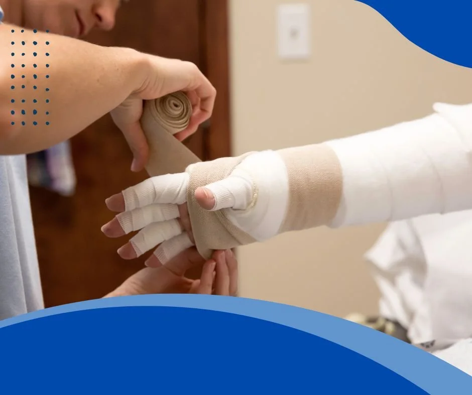 Person wrapping a bandage around a patient's hand to secure a cast or splint for injury support.