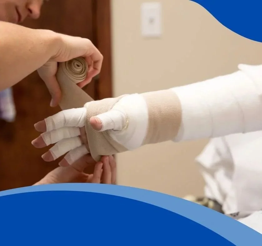 A person wrapping a person's hand with a medical bandage.