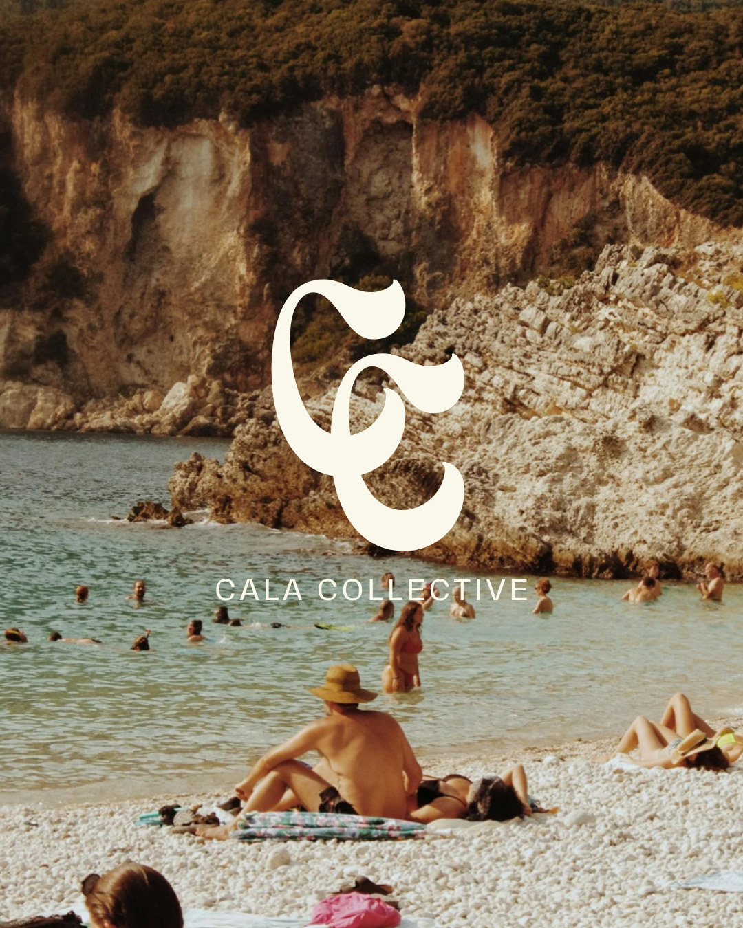 People relaxing and swimming at a rocky beach with cliffs in the background.