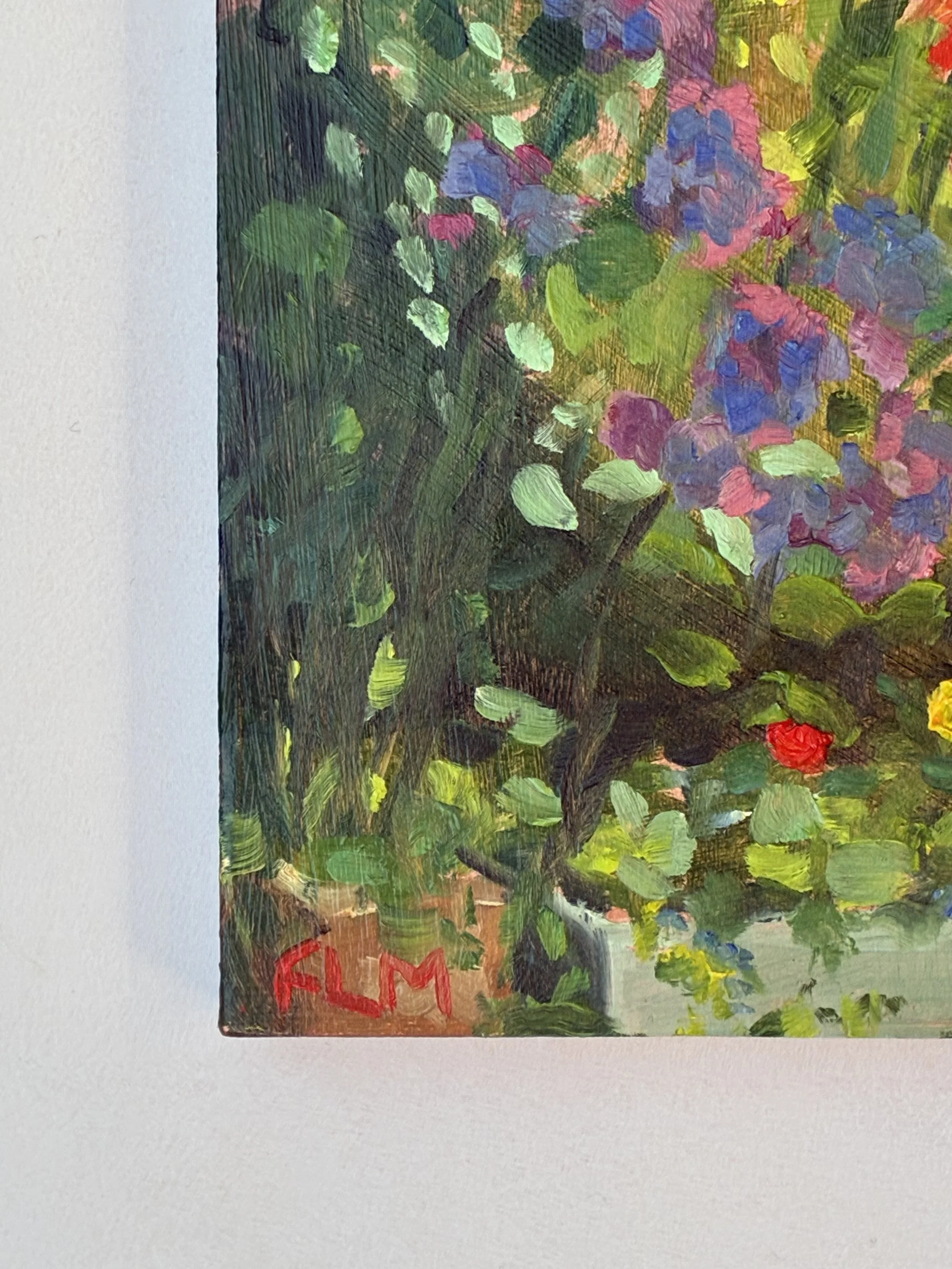 Close up artist signature on a colourful impressionistic garden painting, showing green leaves and pink, purple, yellow, and red flowers or blossoms.