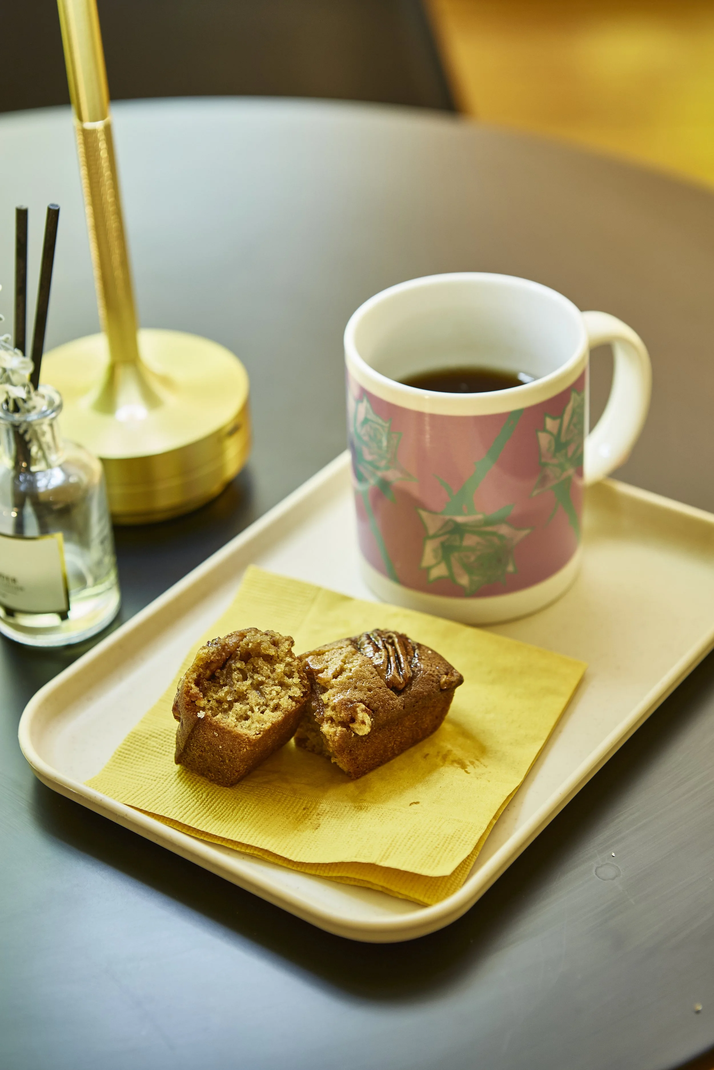 컵에 담긴 커피와 그 옆에 쿠키 두 조각이 담긴 쟁반.