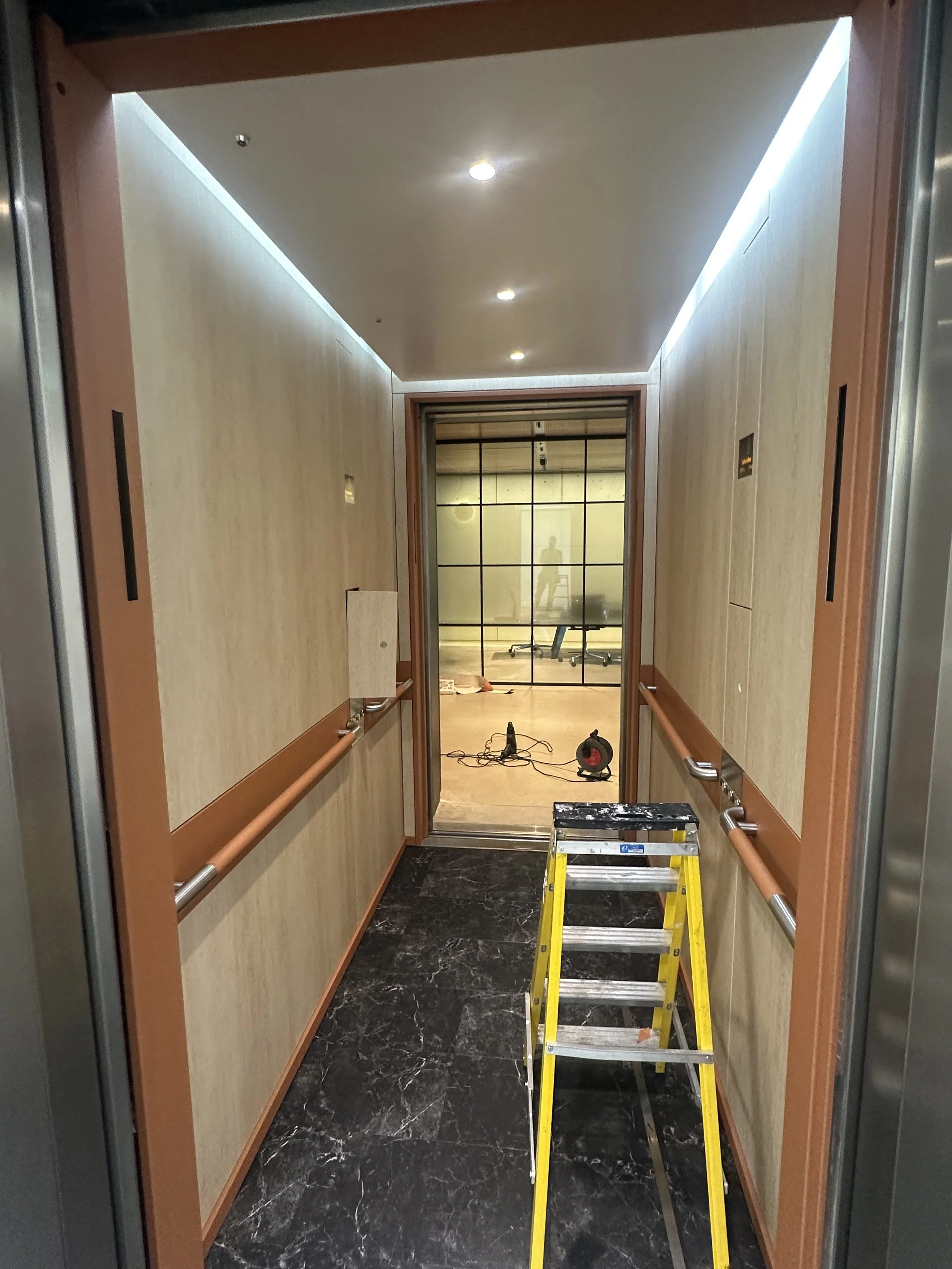 a lift refurbished with the walls and panels wrapped in architectural wood.
