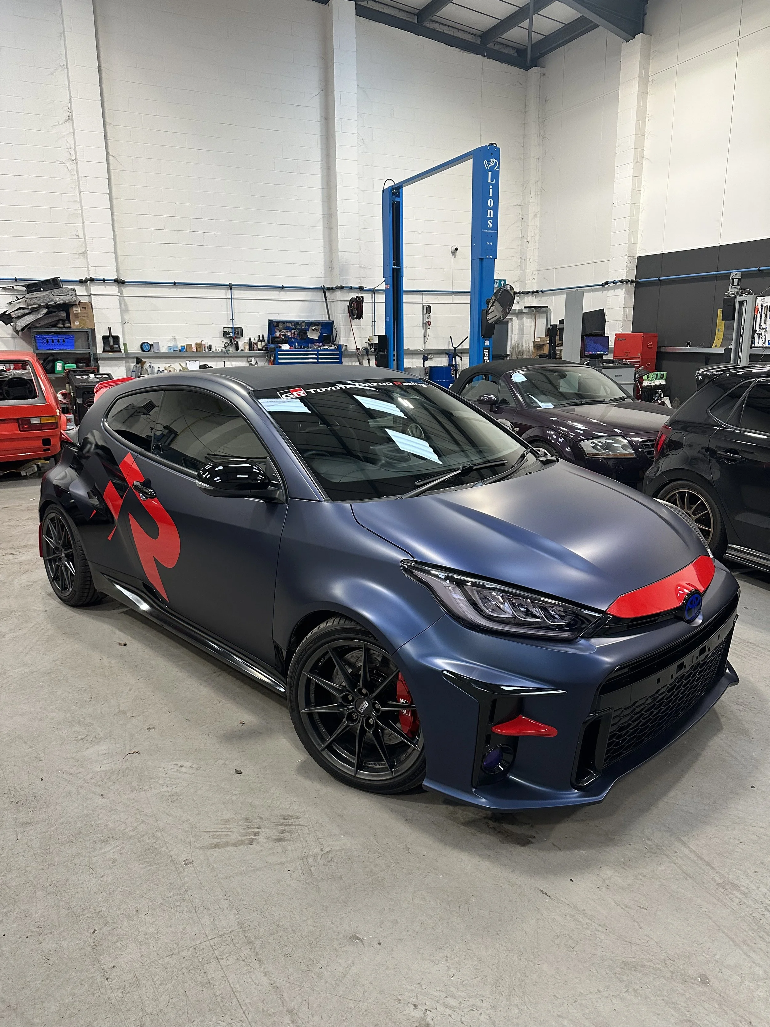toyota yaris gr wrapped in satin blue with red accents.